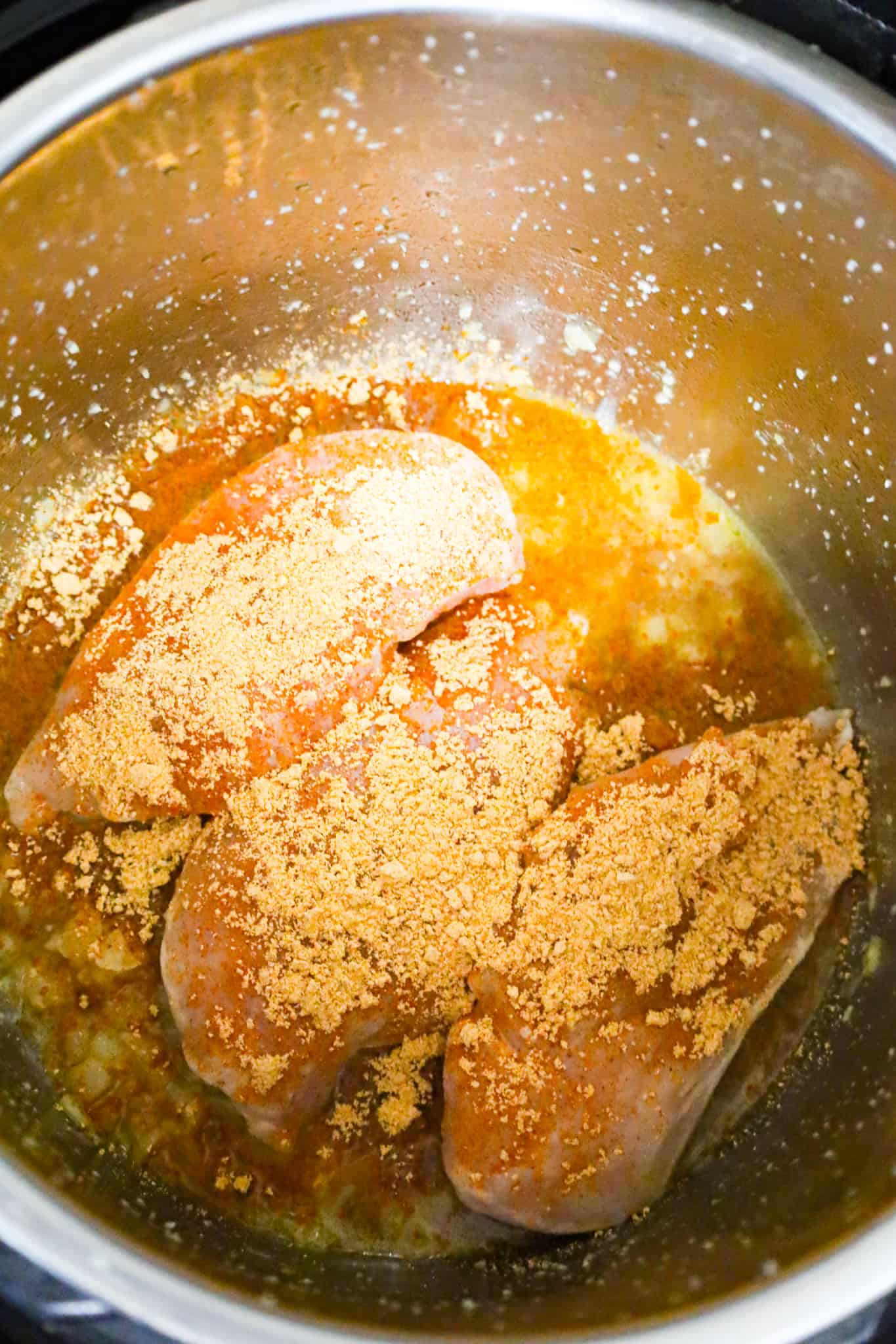 taco seasoning on top of raw chicken breasts in an Instant Pot