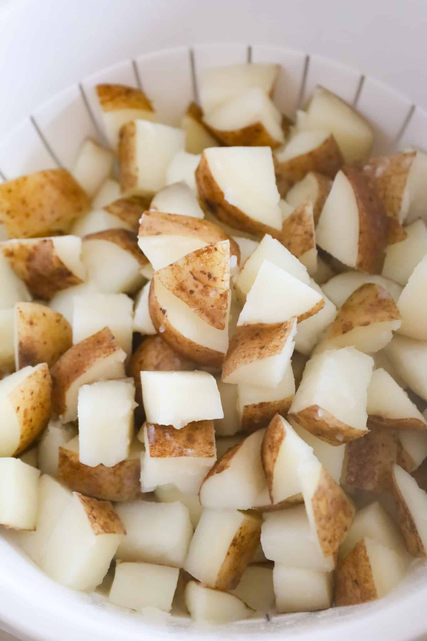 cooked diced potatoes in a colander