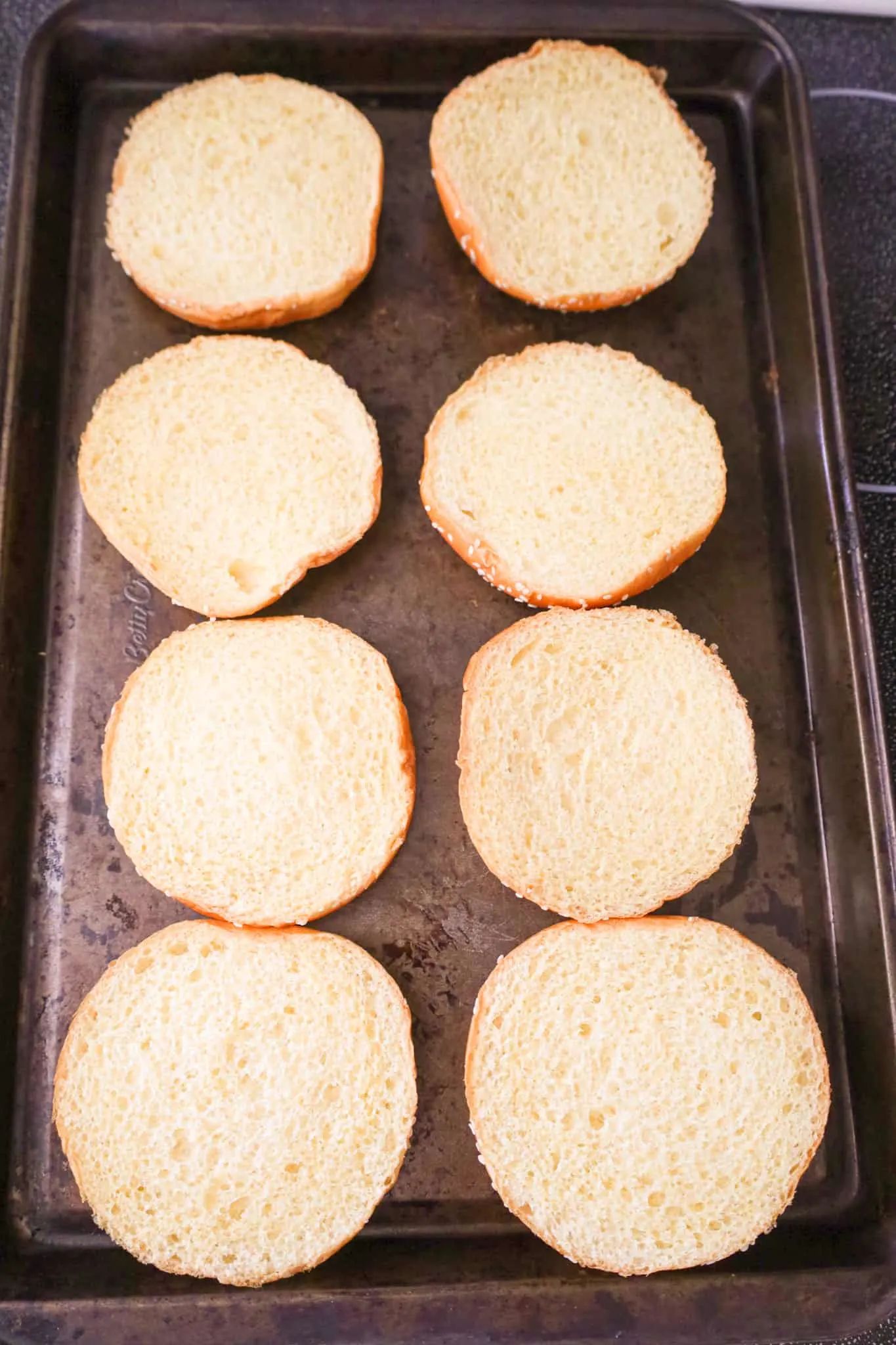 brioche buns in a single layer on a baking sheet
