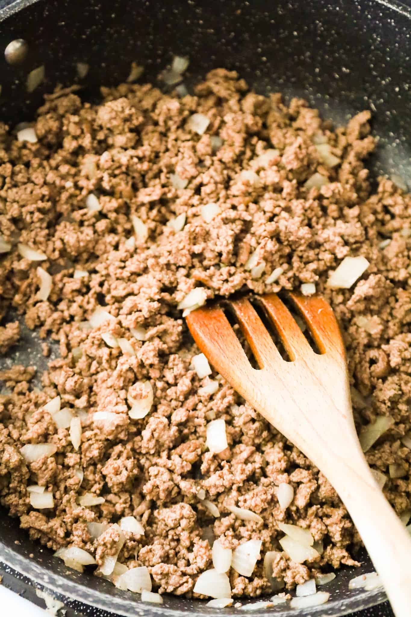 cooked ground beef and diced onions in a saute pan