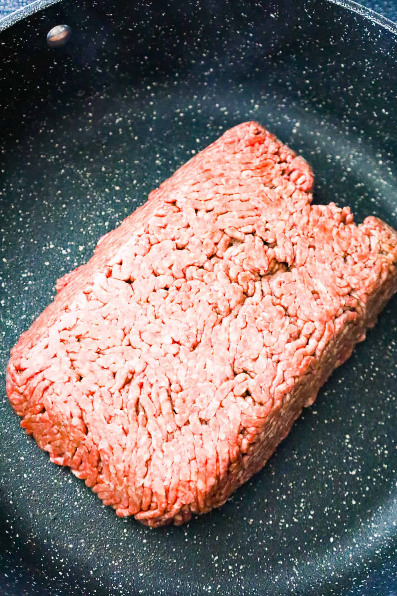 raw ground beef in a saute pan