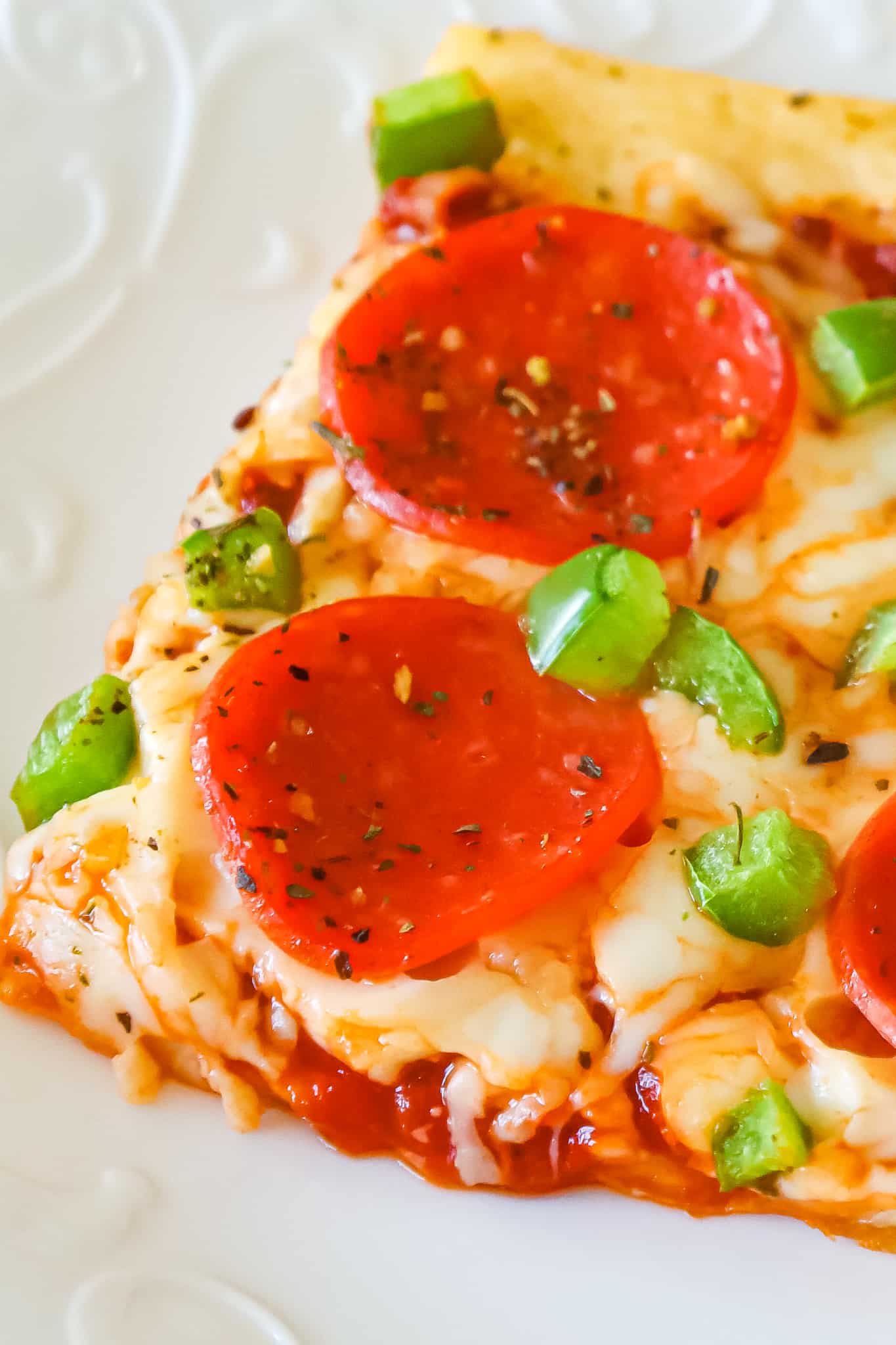 Crescent Roll Pizza is an easy weeknight dinner recipe using a can of Pillsbury crescent dough topped with pizza sauce, shredded mozzarella cheese, pepperoni and diced green peppers.