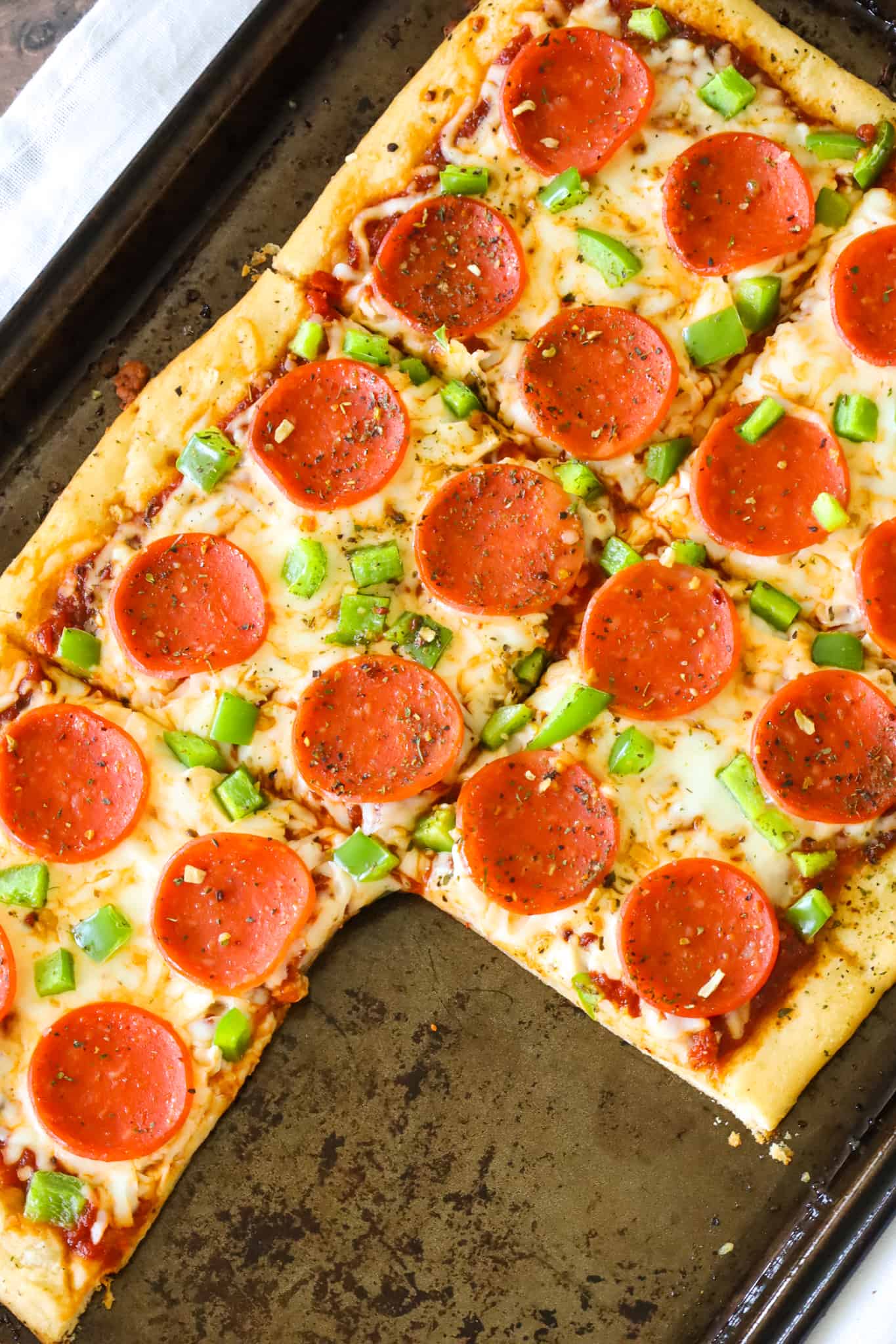 Crescent Roll Pizza is an easy weeknight dinner recipe using a can of Pillsbury crescent dough topped with pizza sauce, shredded mozzarella cheese, pepperoni and diced green peppers.