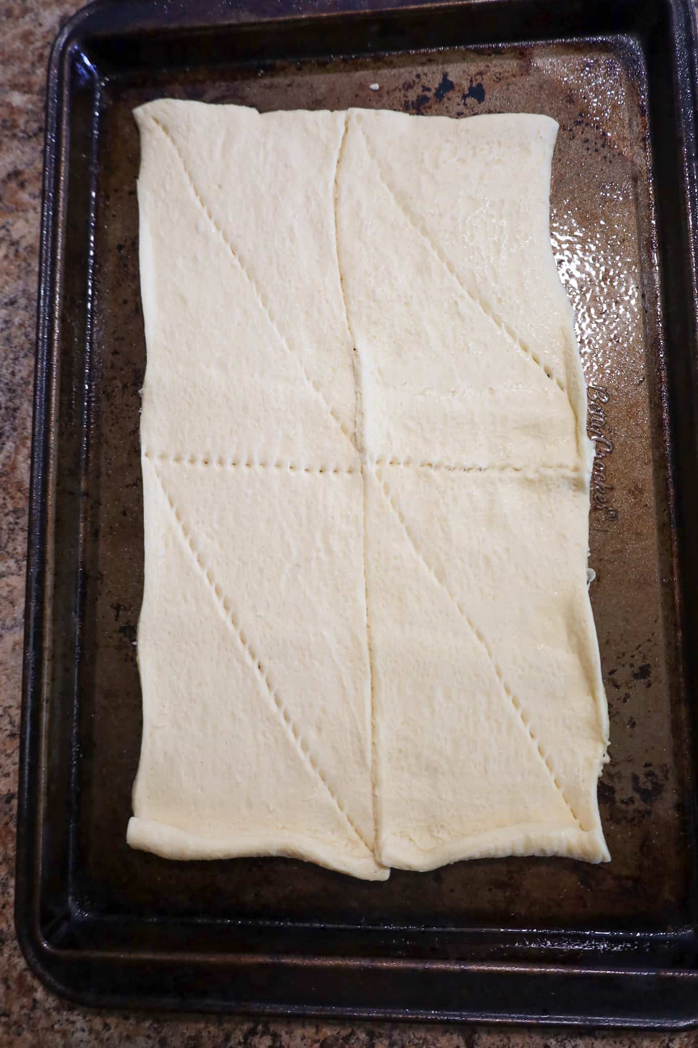 crescent dough on greased baking sheet