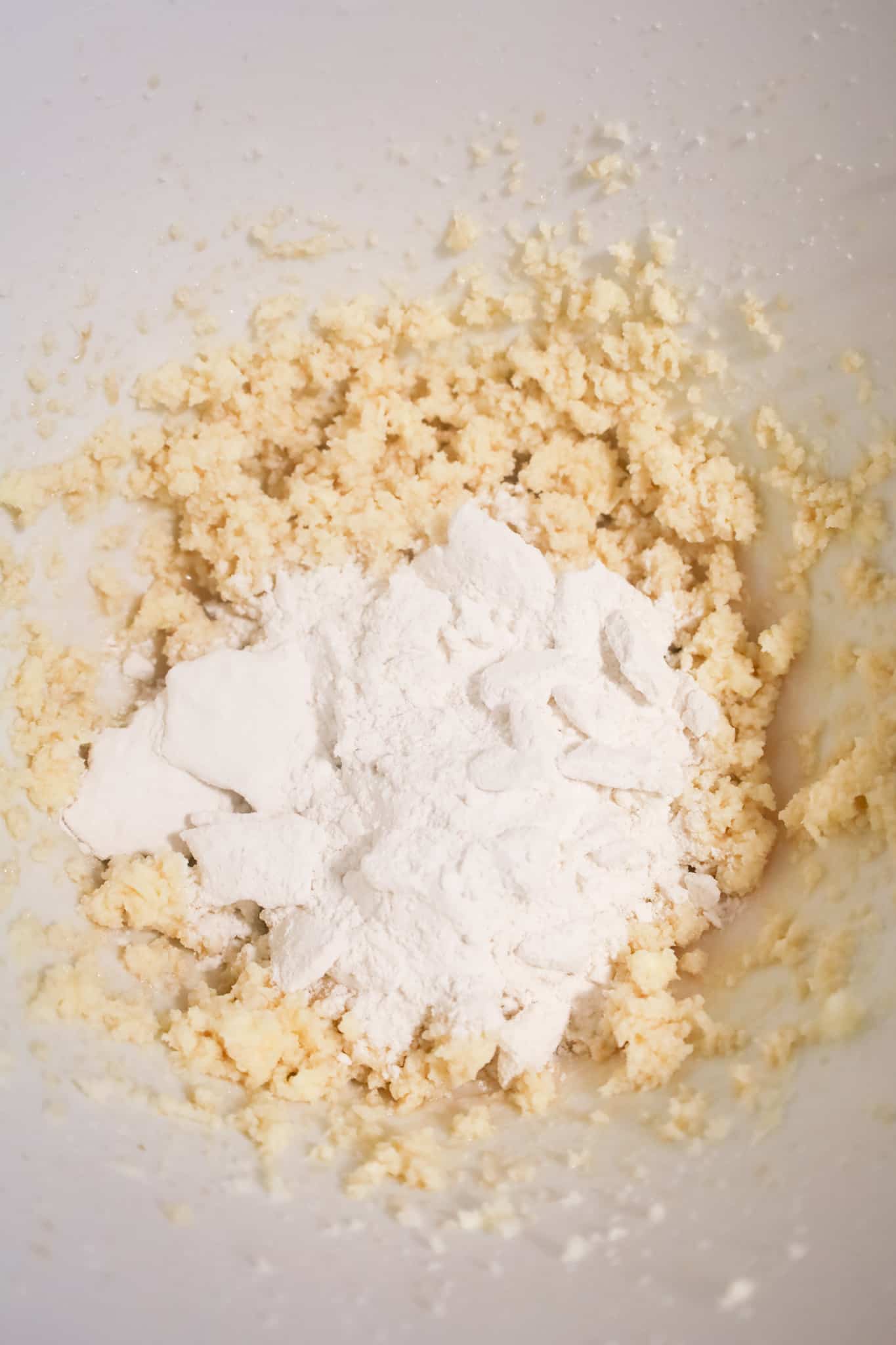 heat treated flour on top of creamed sugar and butter mixture in a mixing bowl