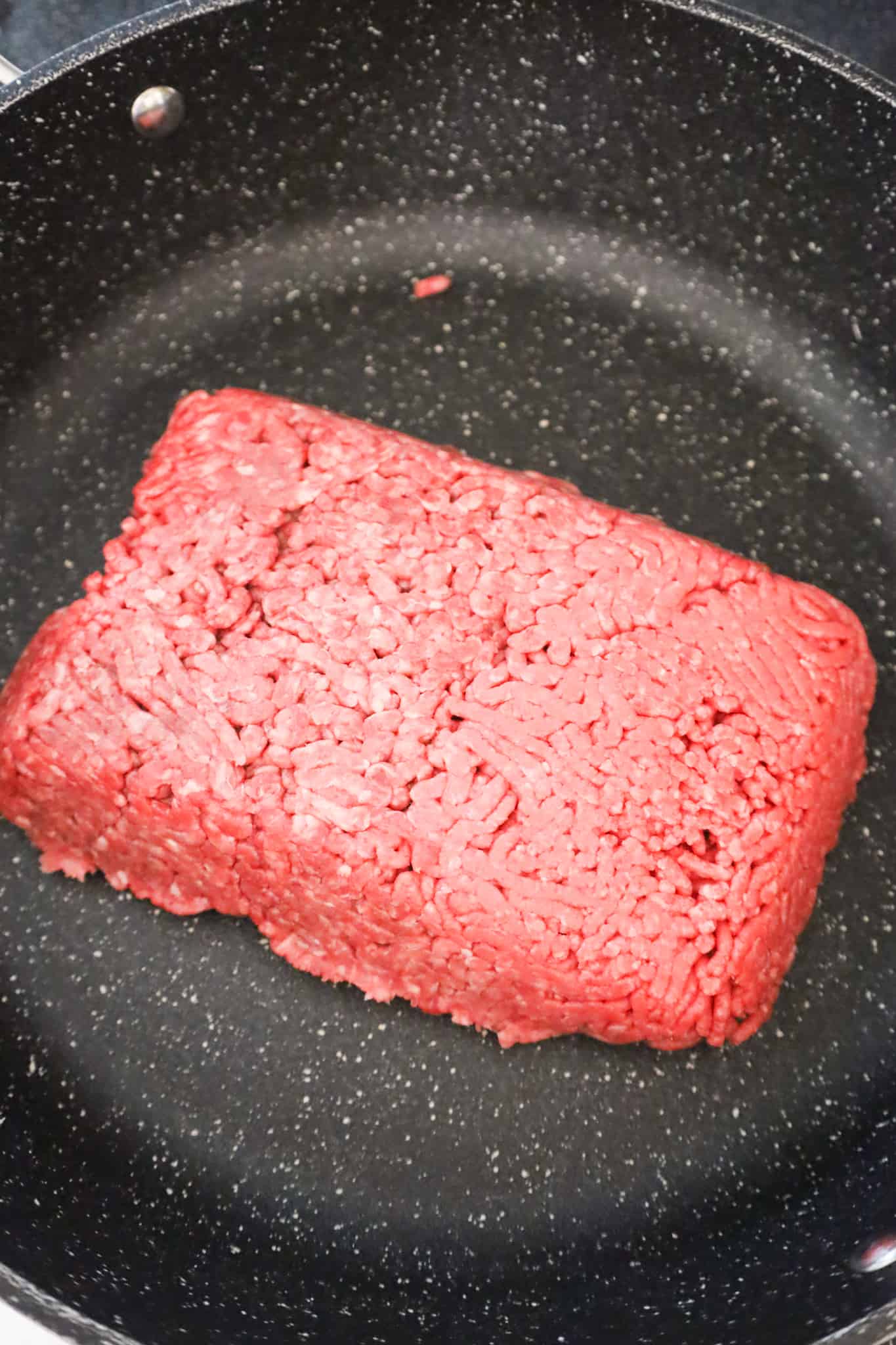 raw ground beef in a saute pan