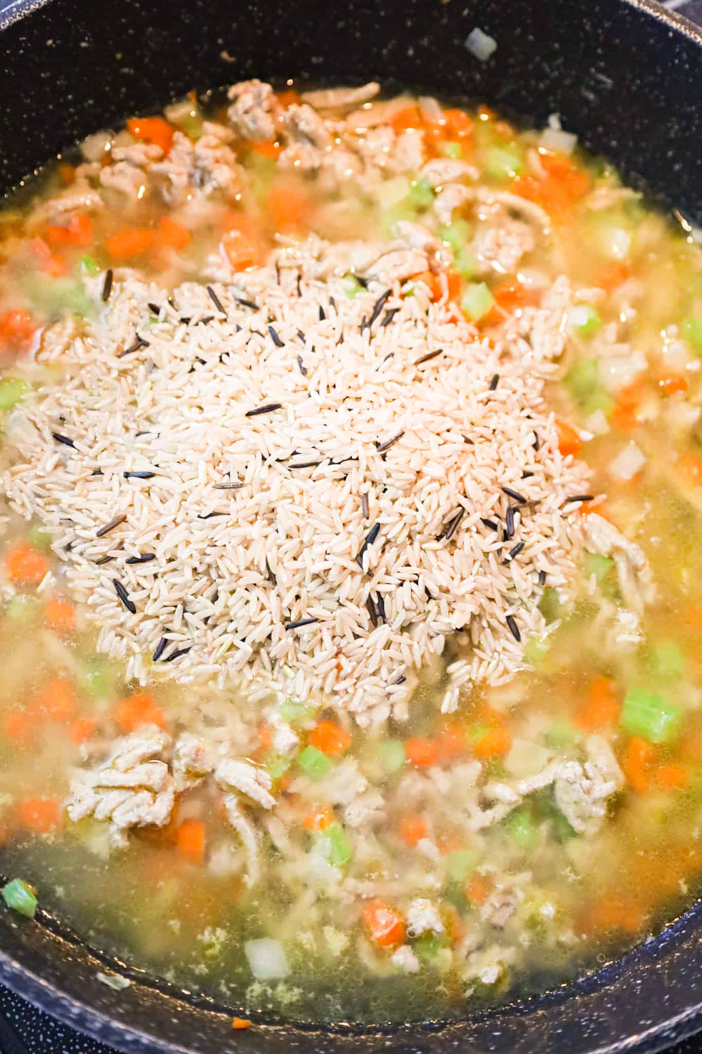uncooked brown and wild rice blend added to chicken broth, ground turkey and diced veggies