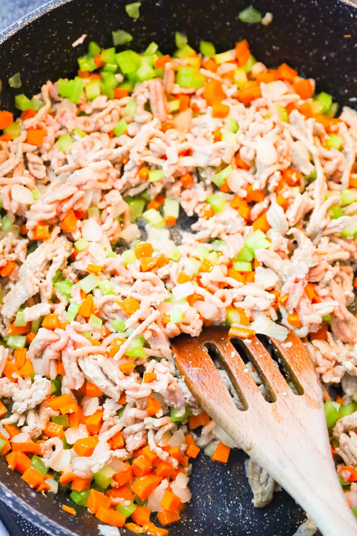 ground turkey and diced veggies cooking in a skillet