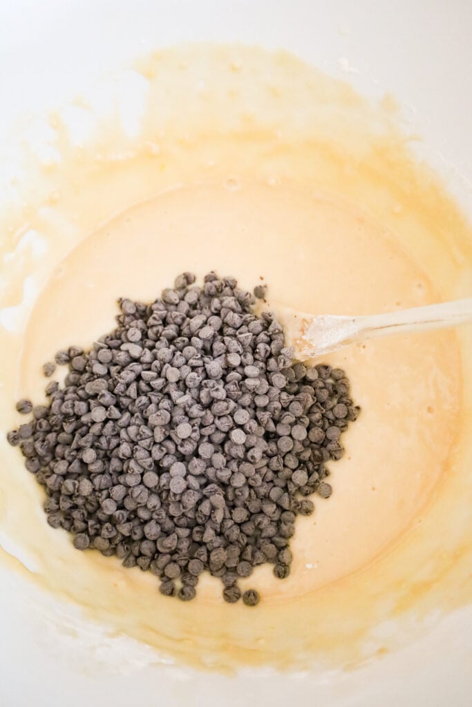 mini chocolate chips on top of muffin batter in a mixing bowl