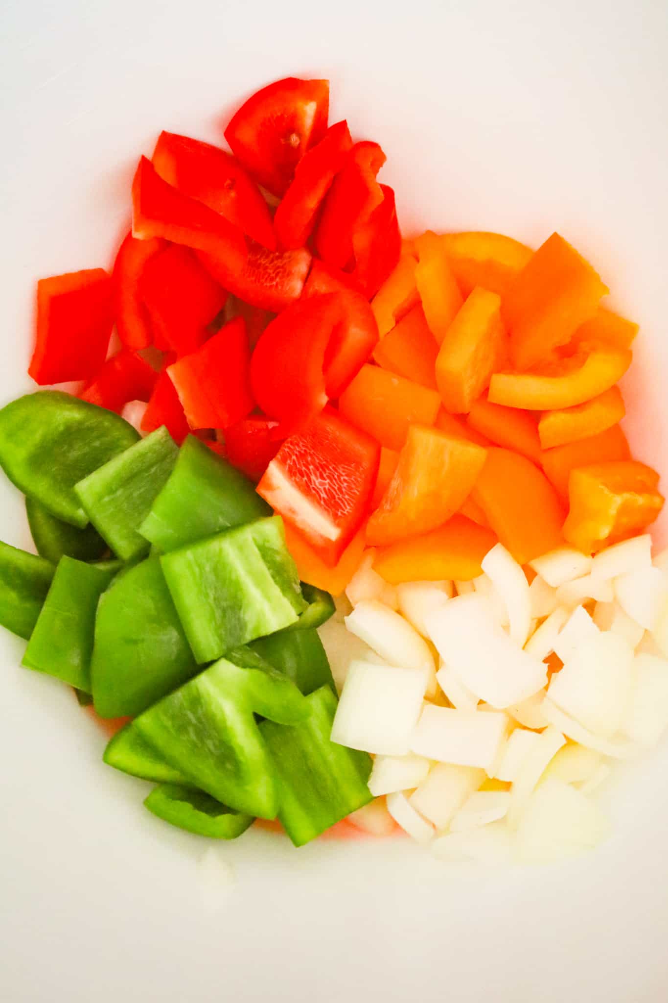 diced onions and peppers in a mixing bowl