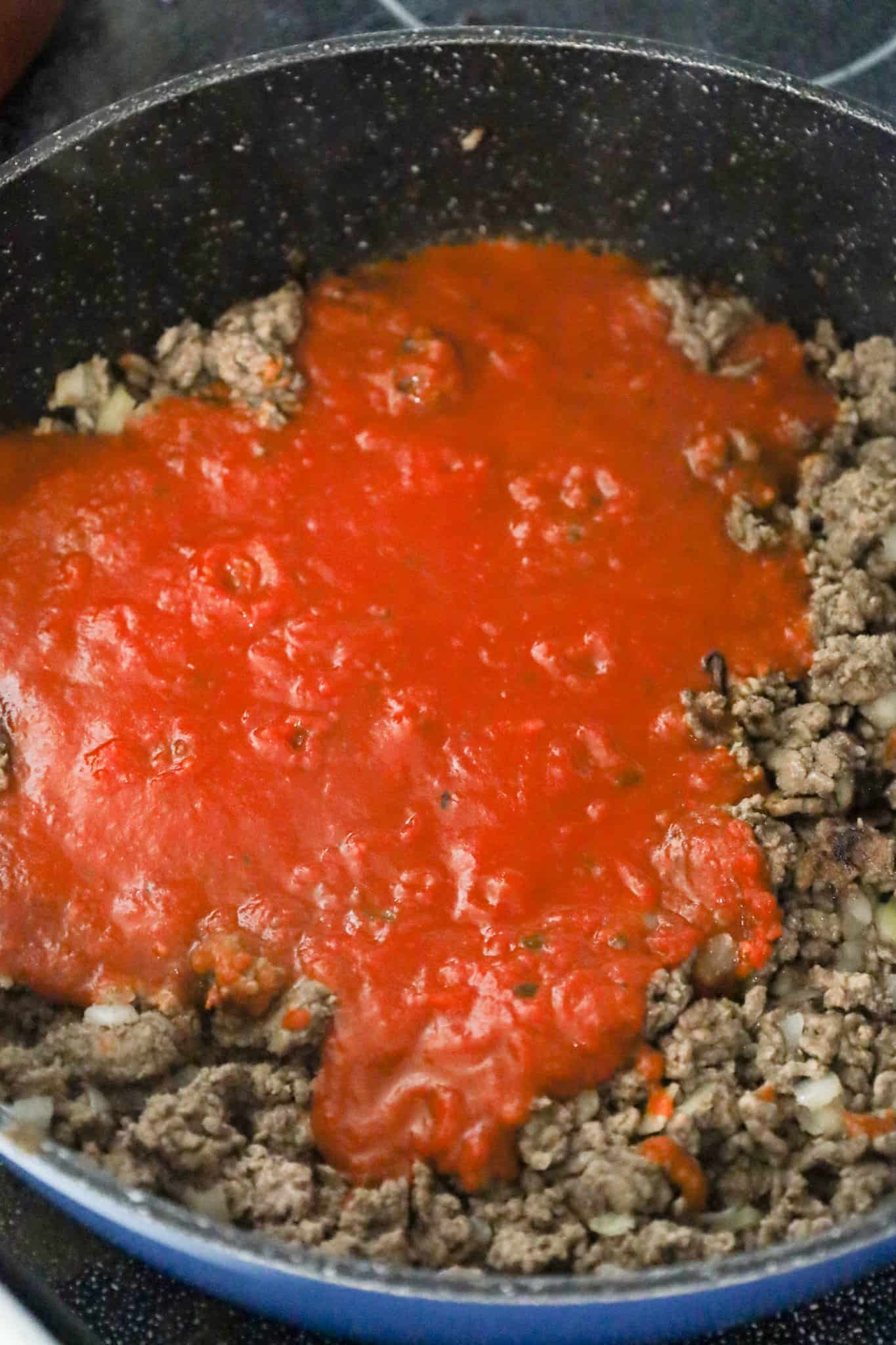 marinara sauce added to pan with cooked ground beef