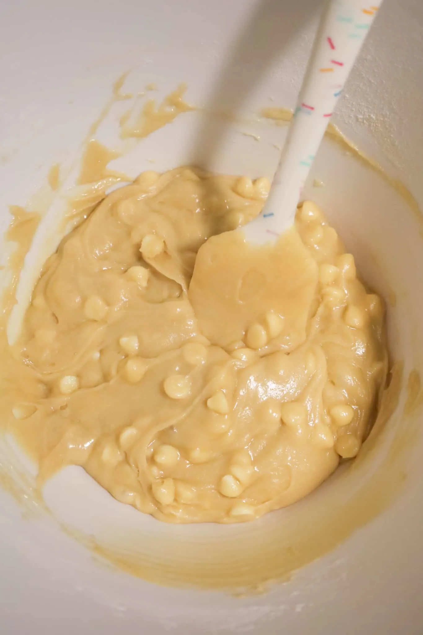 vanilla brownie batter loaded with white chocolate chips in a mixing bowl