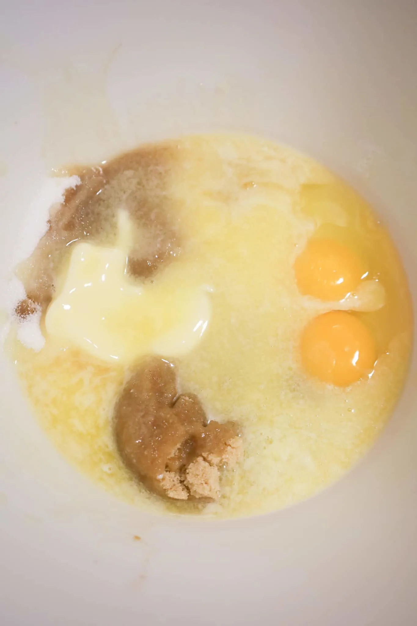 melted butter, eggs, vanilla extract, brown sugar and white sugar in a mixing bowl