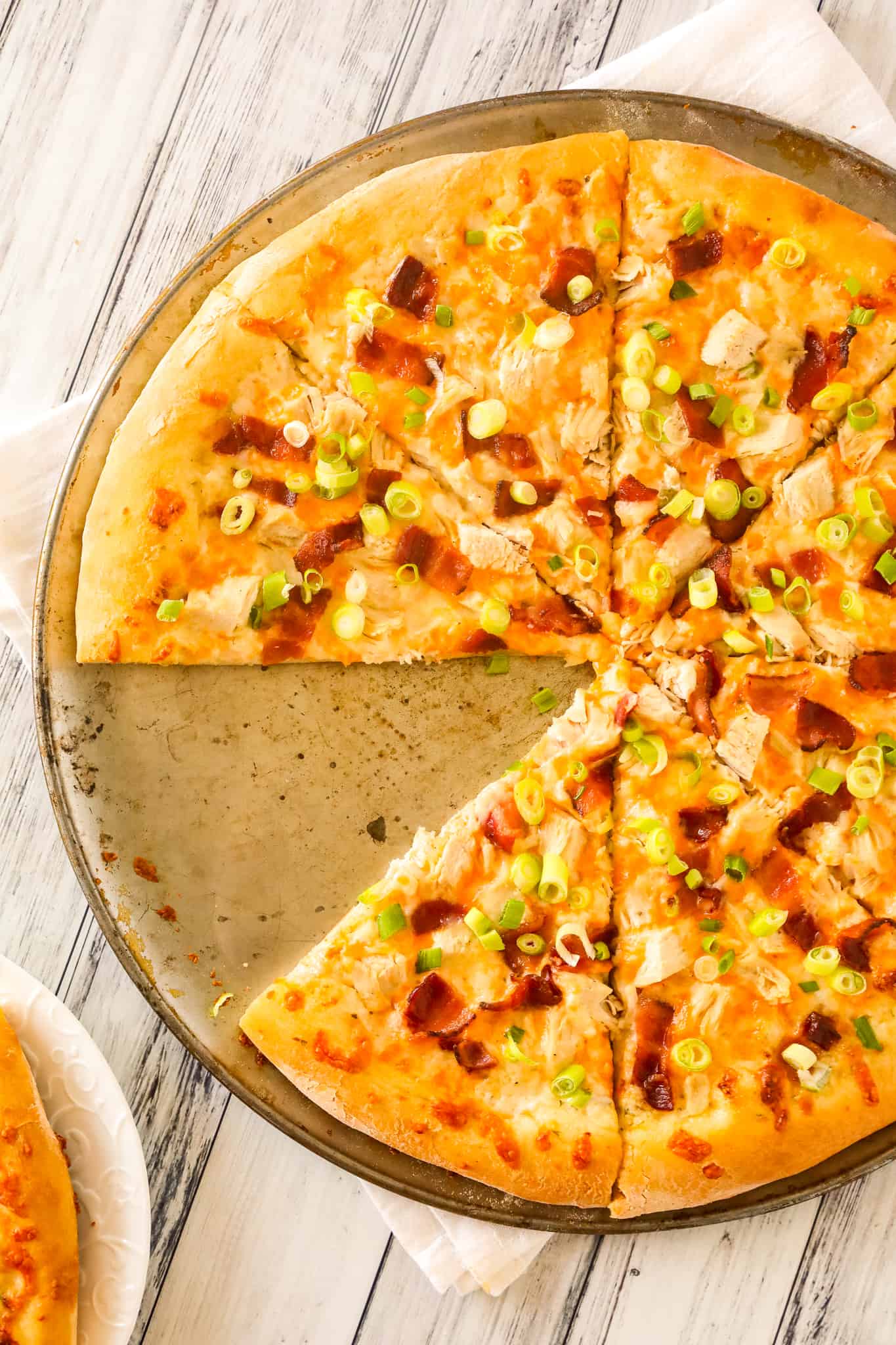 Chicken Bacon Ranch Pizza is an easy dinner recipe using store bought pizza dough loaded with ranch dressing, chicken breast chunks, bacon, chopped green onions and shredded mozzarella and cheddar cheese.
