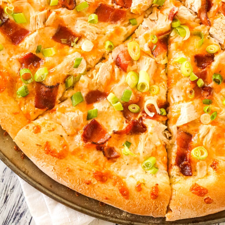 Chicken Bacon Ranch Pizza is an easy dinner recipe using store bought pizza dough loaded with ranch dressing, chicken breast chunks, bacon, chopped green onions and shredded mozzarella and cheddar cheese.