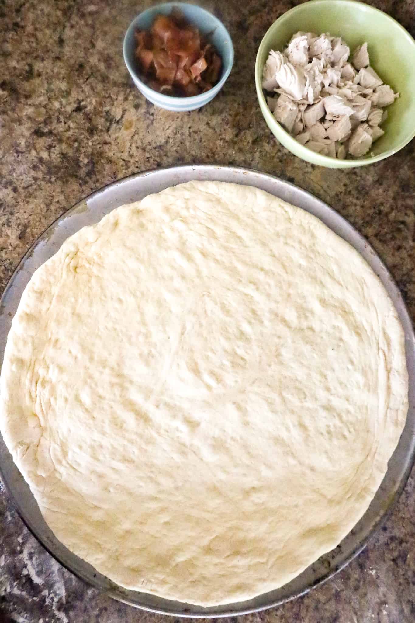 pizza dough on a pan before baking