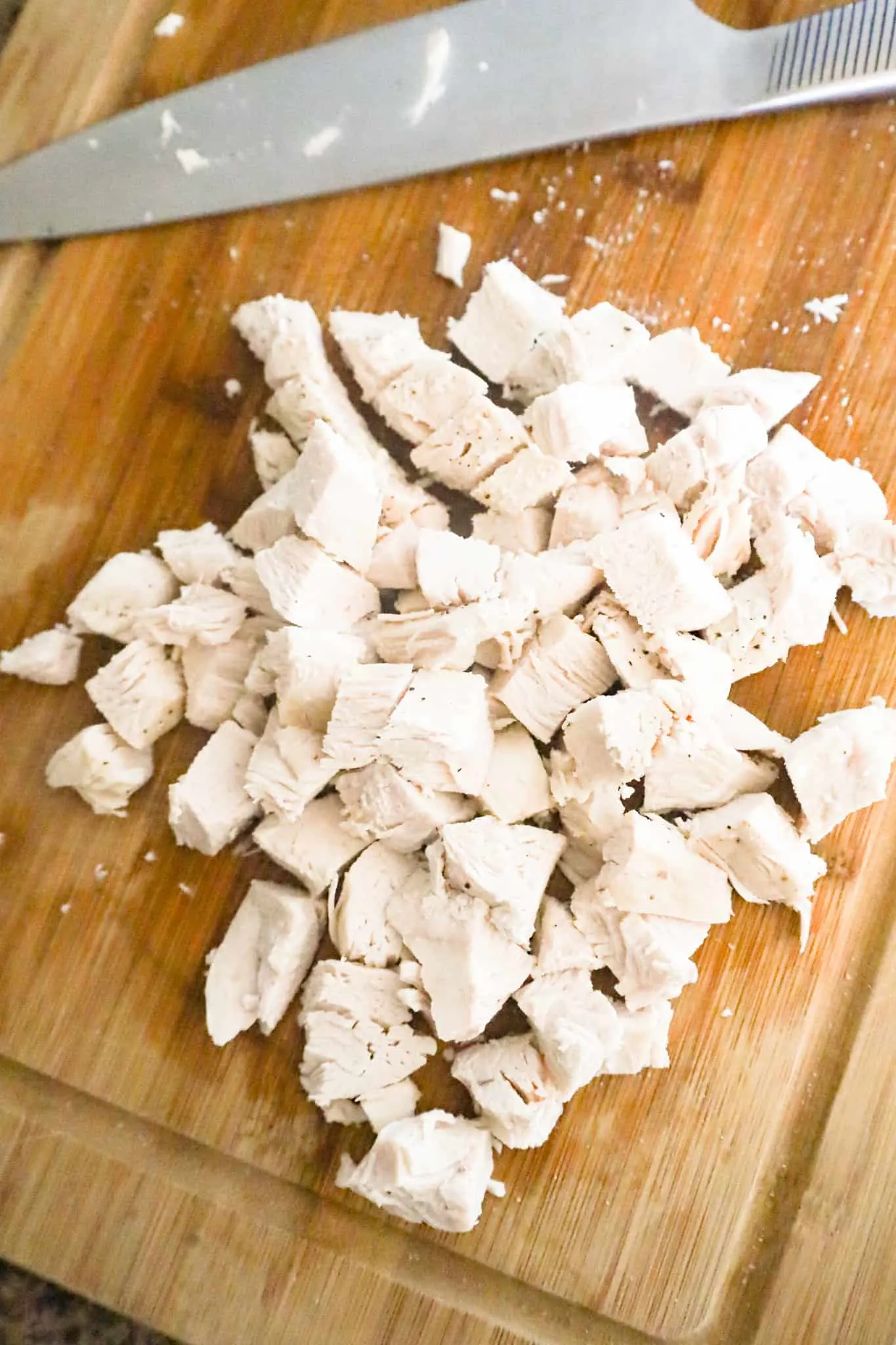 chopped chicken breast chunks on a cutting board