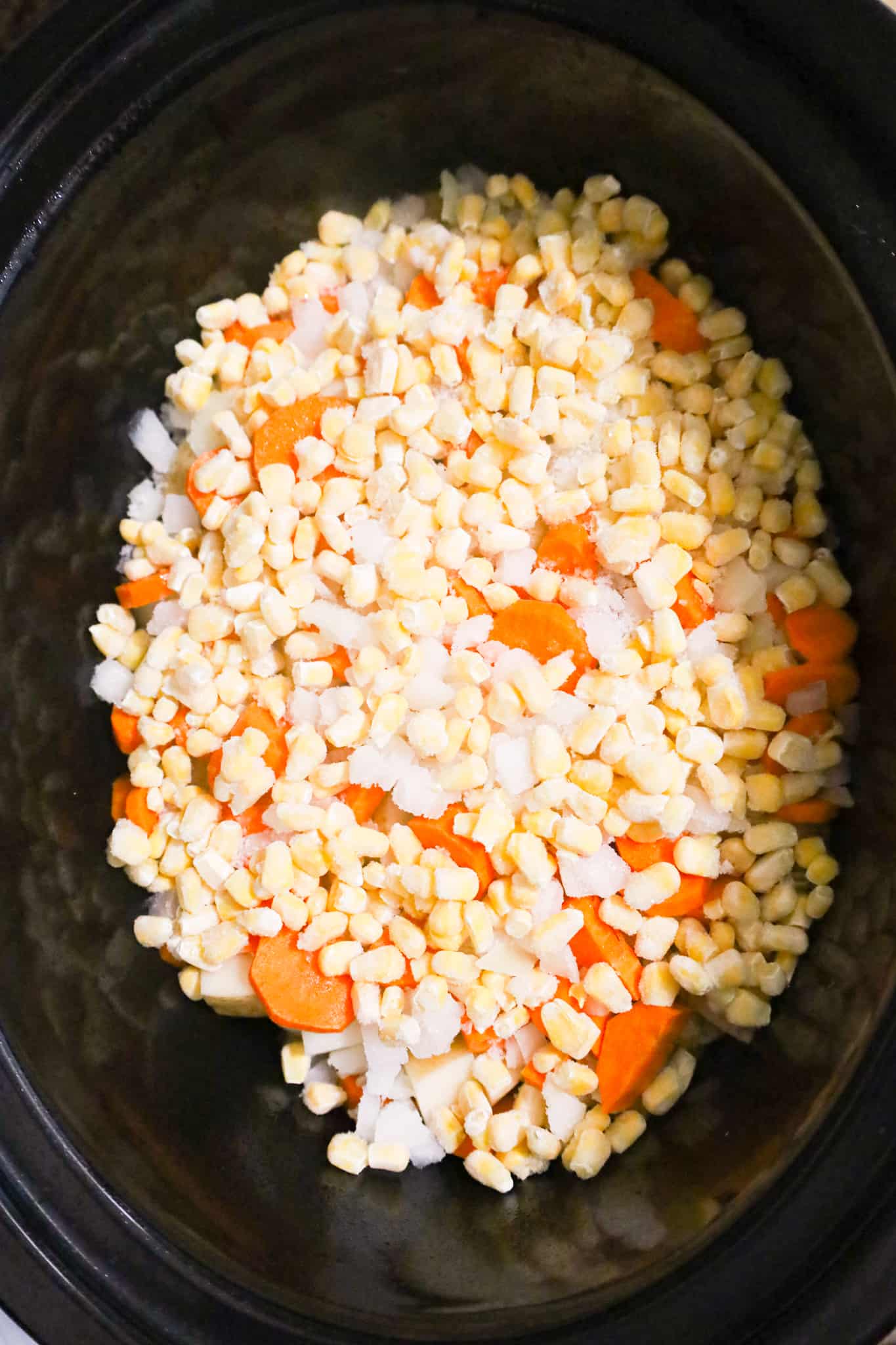 frozen corn, onions, carrots and potatoes in a crock pot