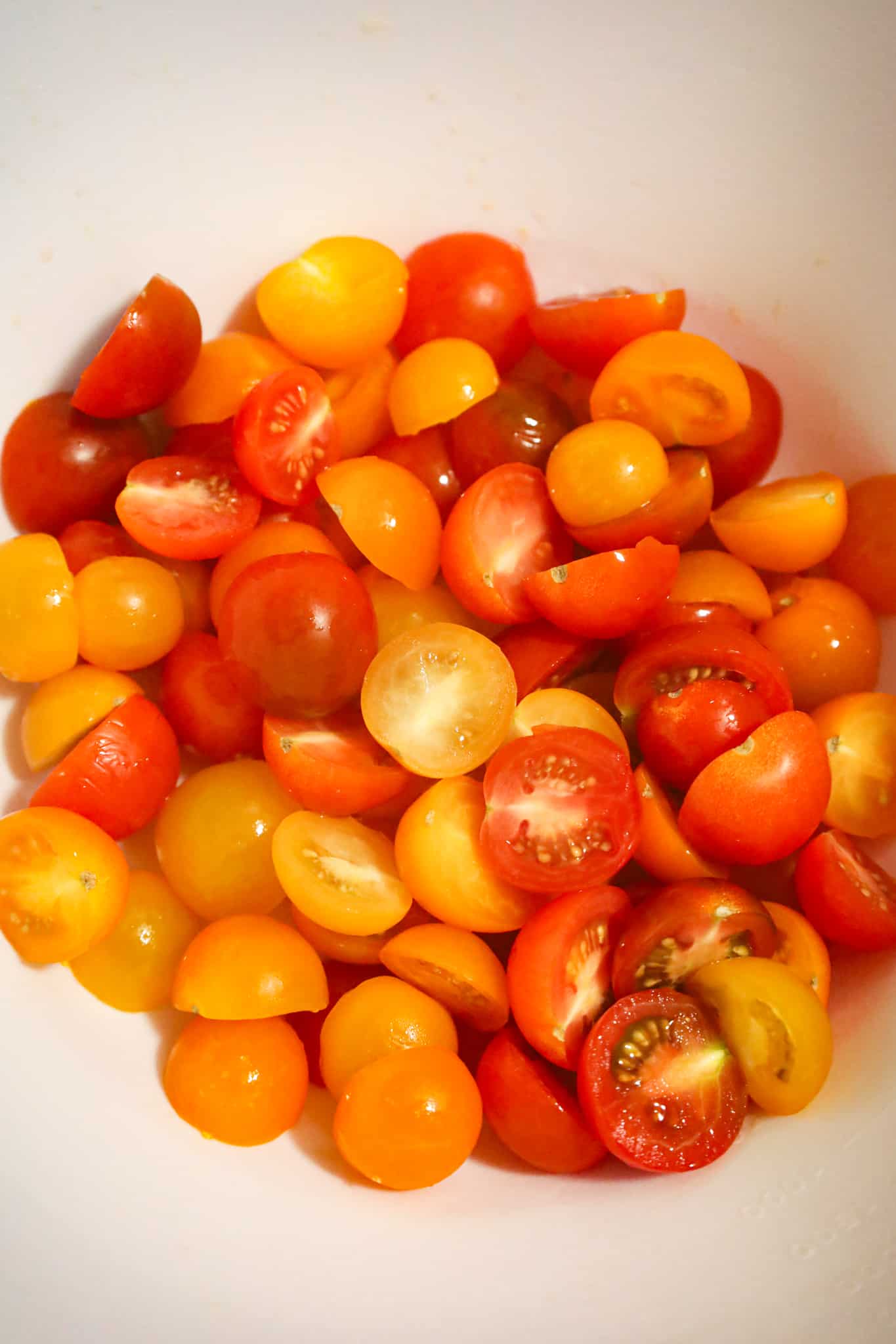 halved cherry tomatoes in a mixing bowl