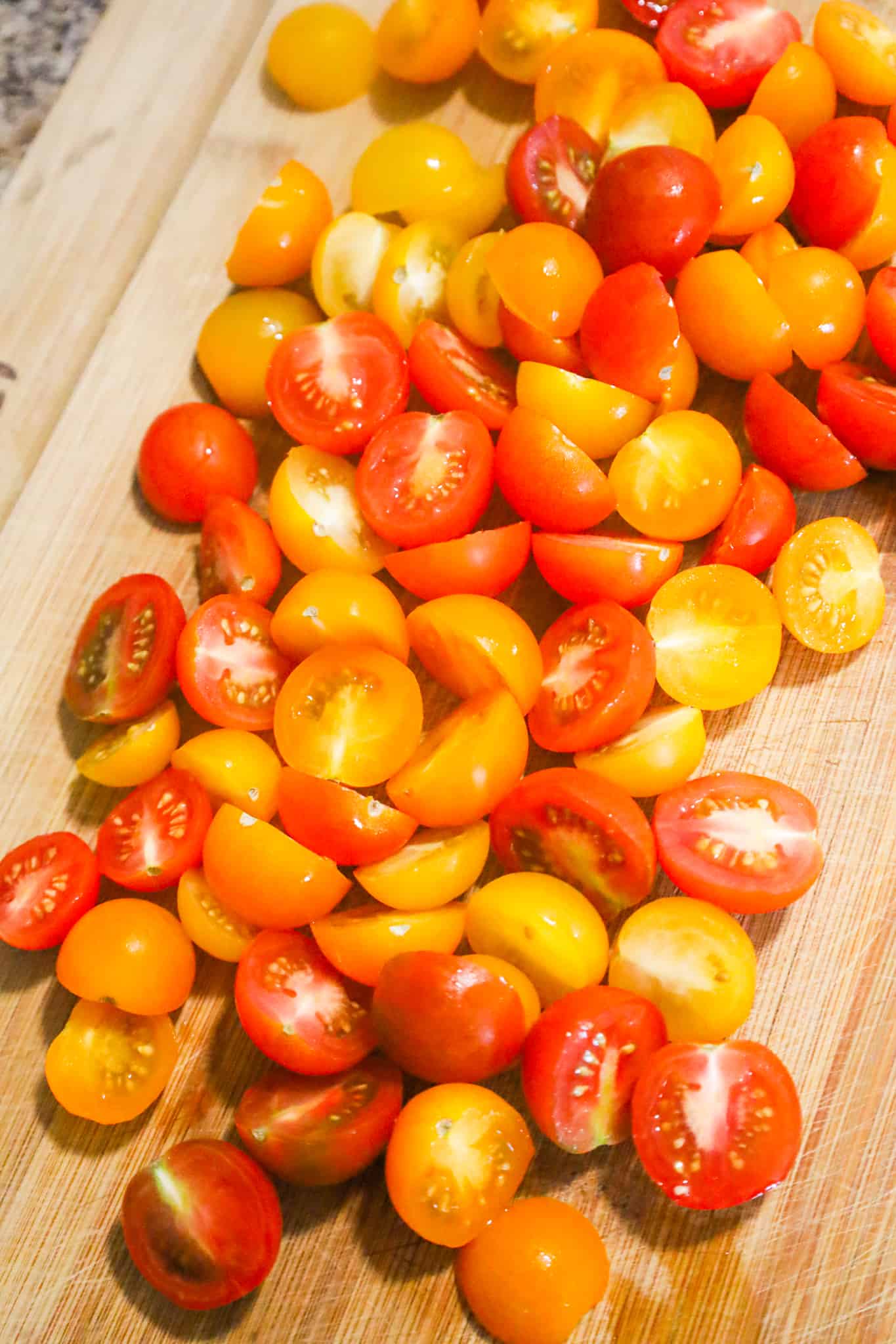 halved cherry tomatoes on a cutting boards