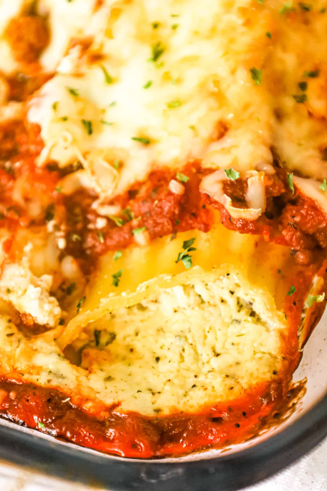 Manicotti is a tasty stuffed pasta recipe loaded with ricotta, sour cream, mozzarella and parmesan cheese smothered in Bolognese sauce and baked with cheese on top.