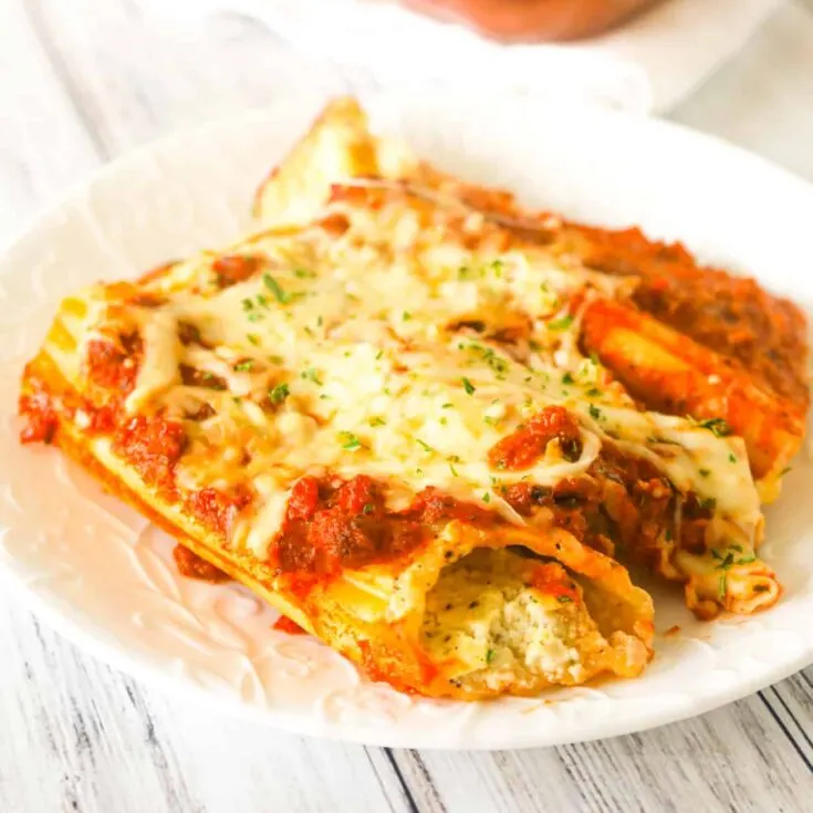 Manicotti is a tasty stuffed pasta recipe loaded with ricotta, sour cream, mozzarella and parmesan cheese smothered in Bolognese sauce and baked with cheese on top.