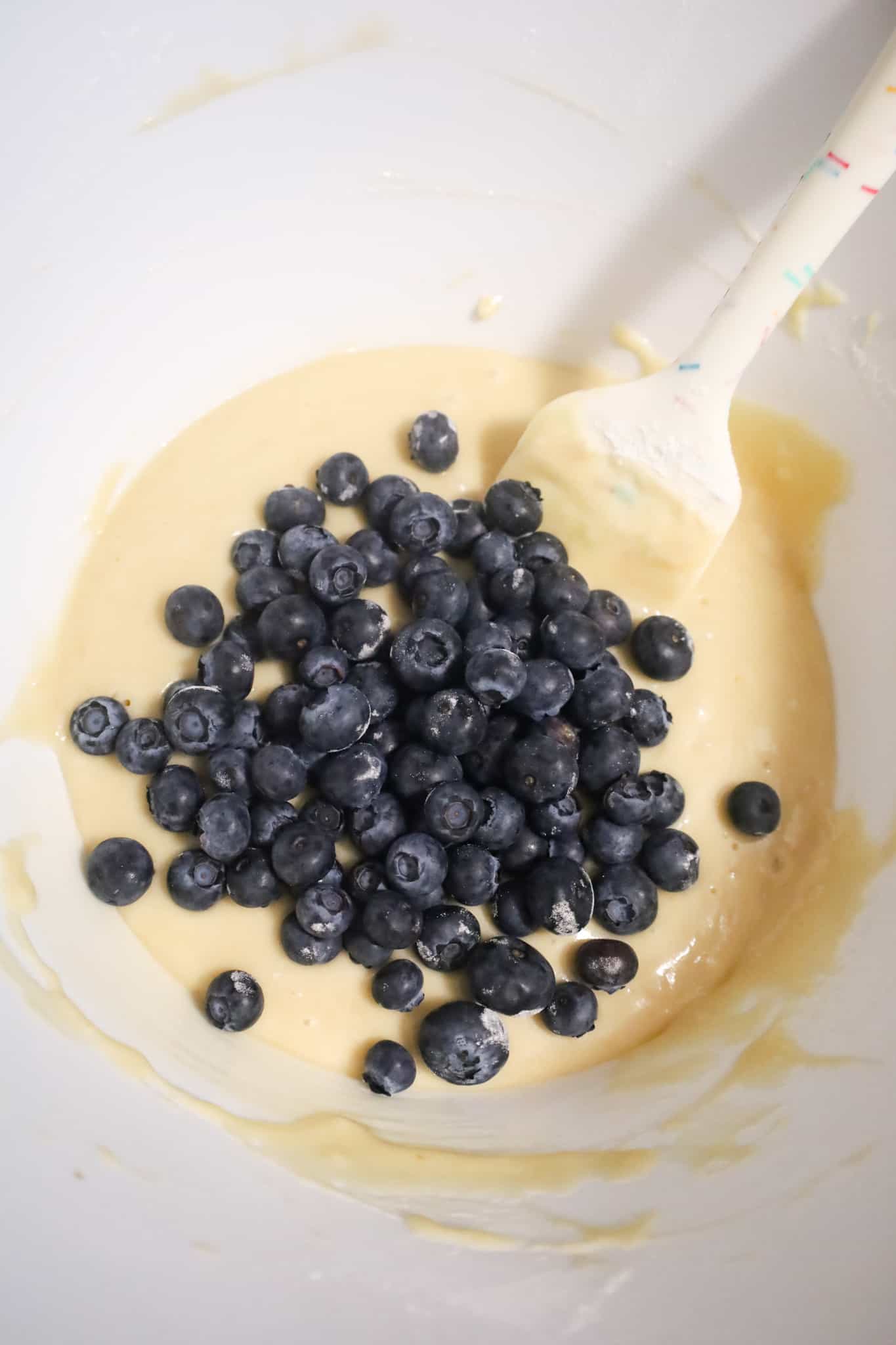 fresh blueberries on top of muffin batter