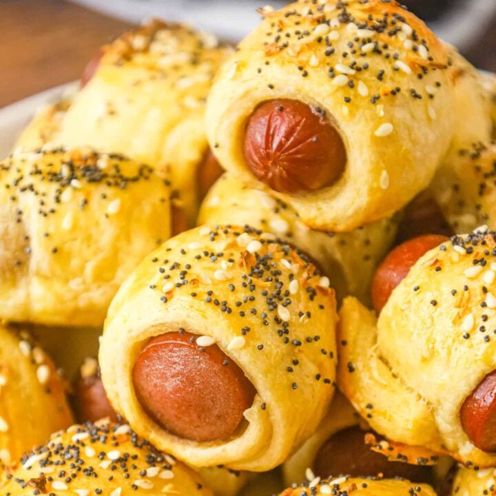 Pigs in a Blanket are a delicious bite sized party food or kid friendly dinner recipe using wieners and Pillsbury crescent roll dough topped with poppy seeds, sesame seeds and dehydrated minced onions.