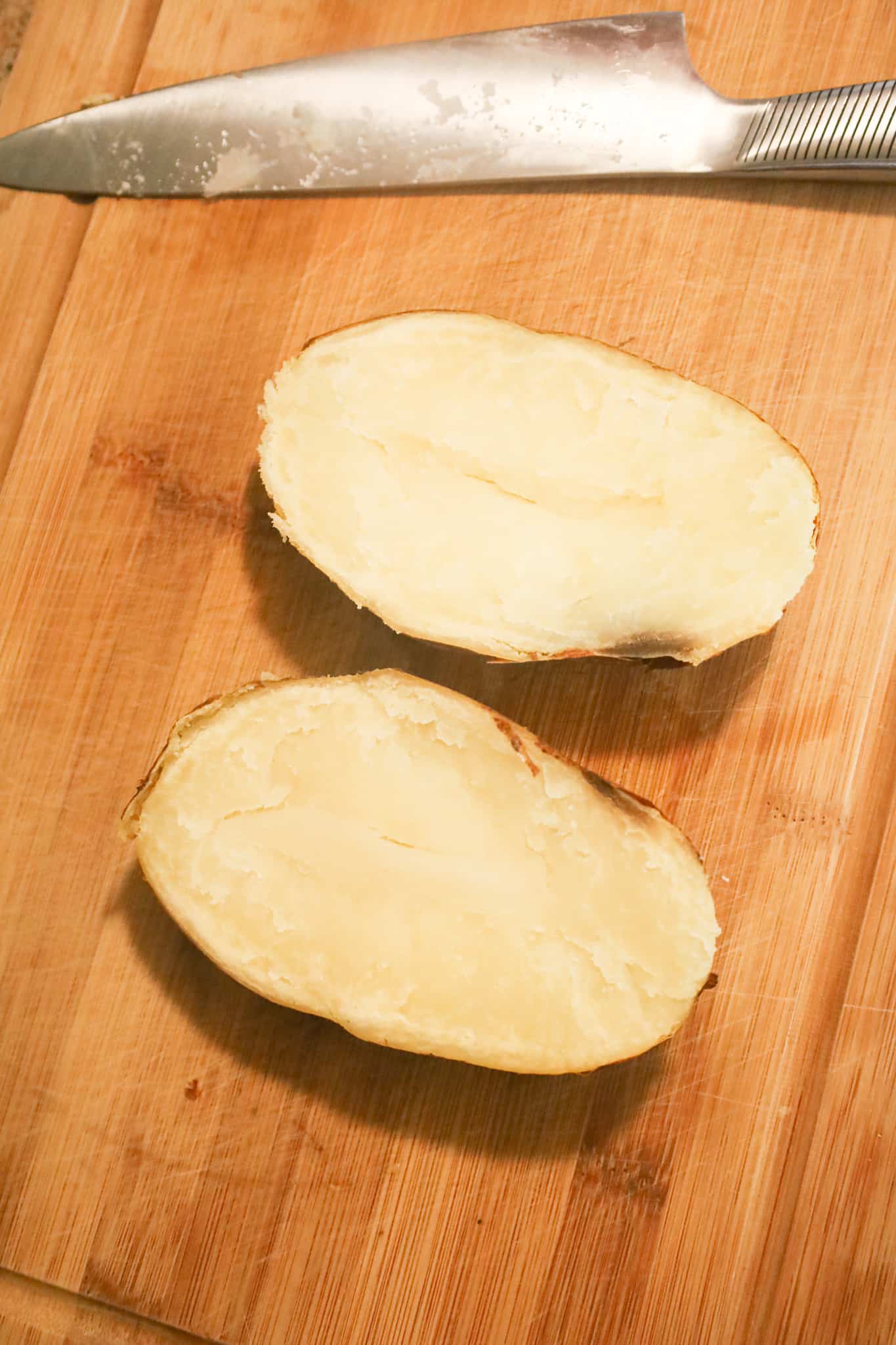 cooked potato halves on a cutting board