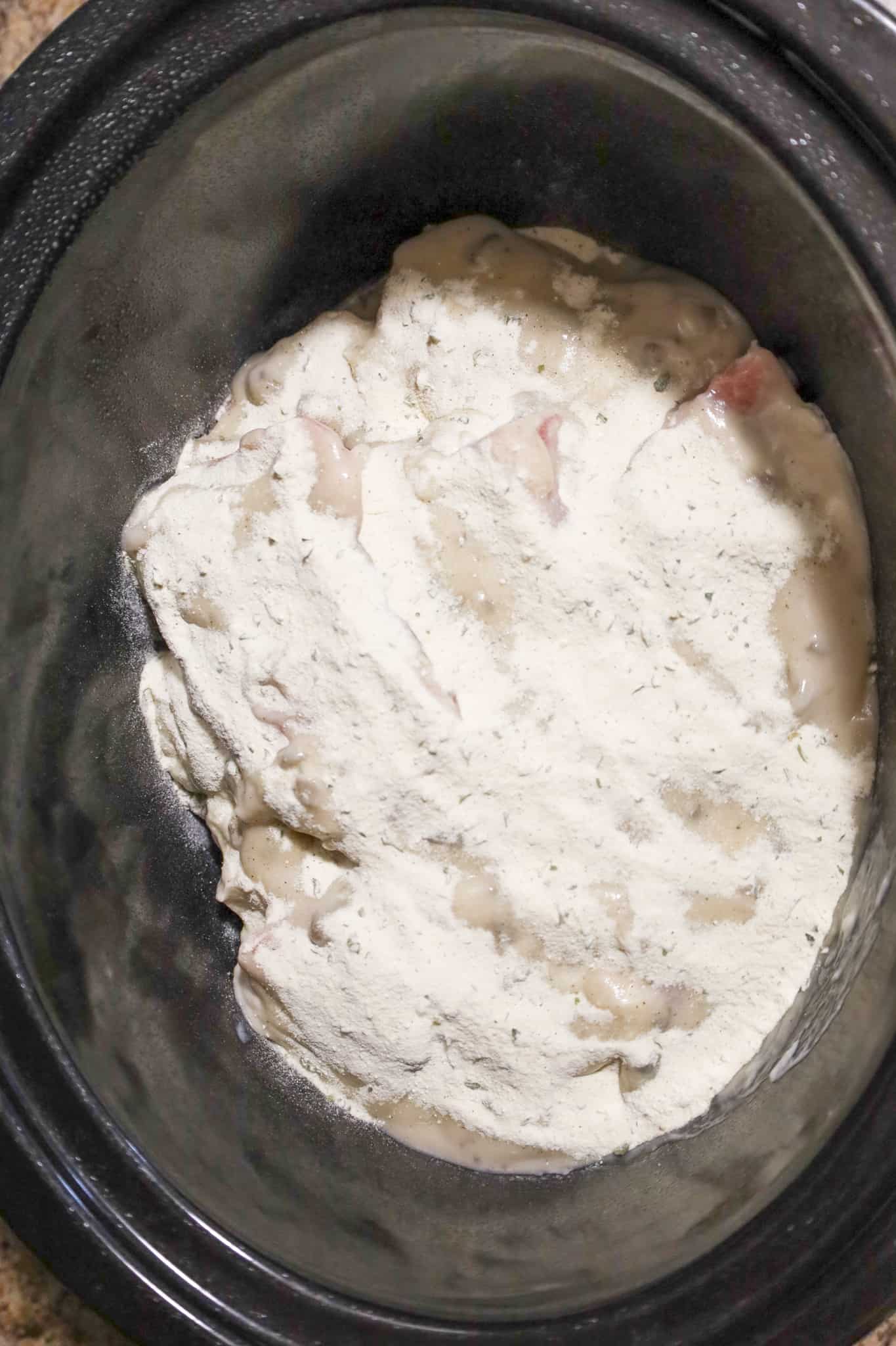 ranch dressing mix on top of cream of mushroom soup and pork chops in a crock pot
