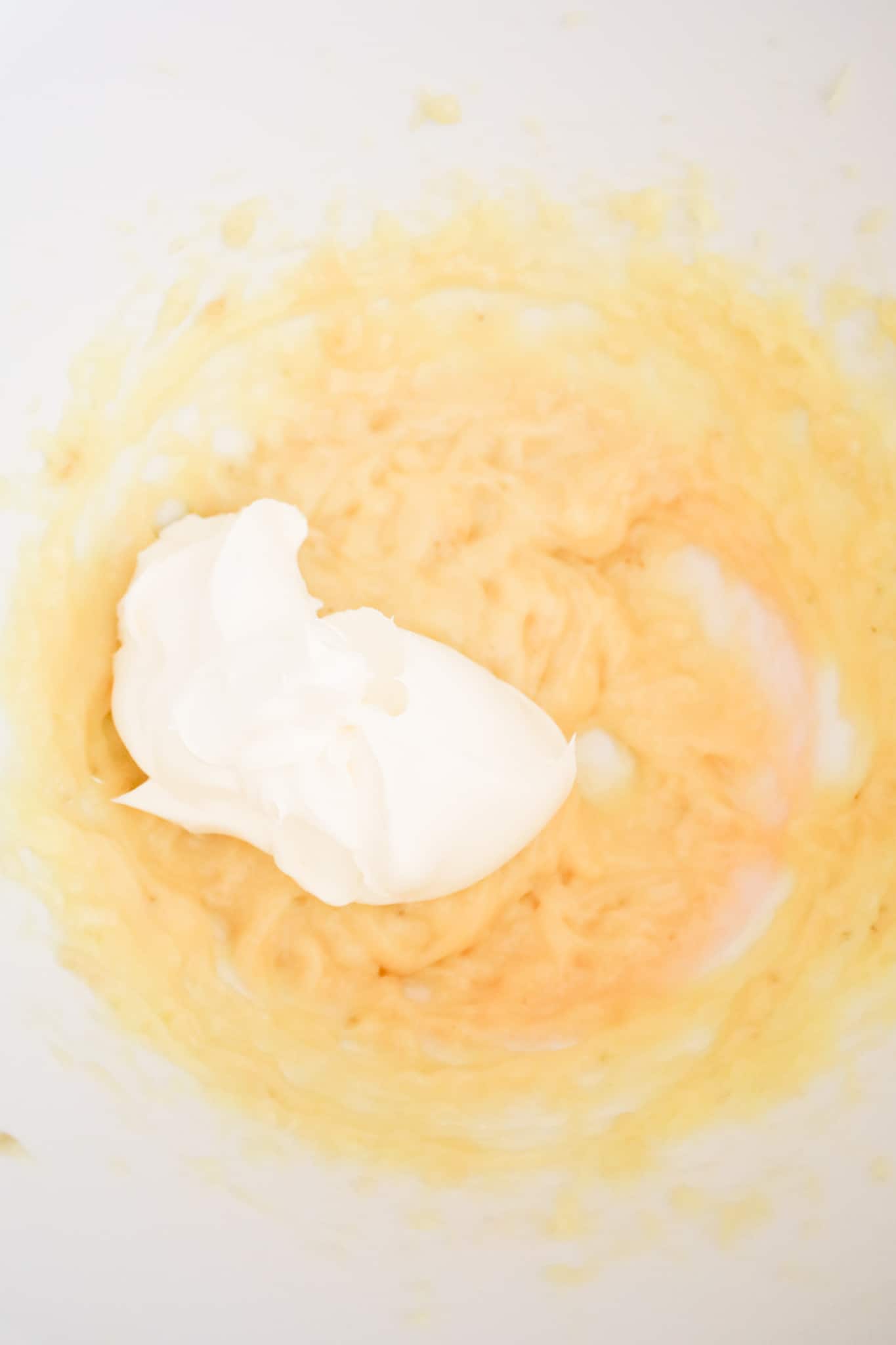 Cool Whip on top of banana pudding mixture in a mixing bowl