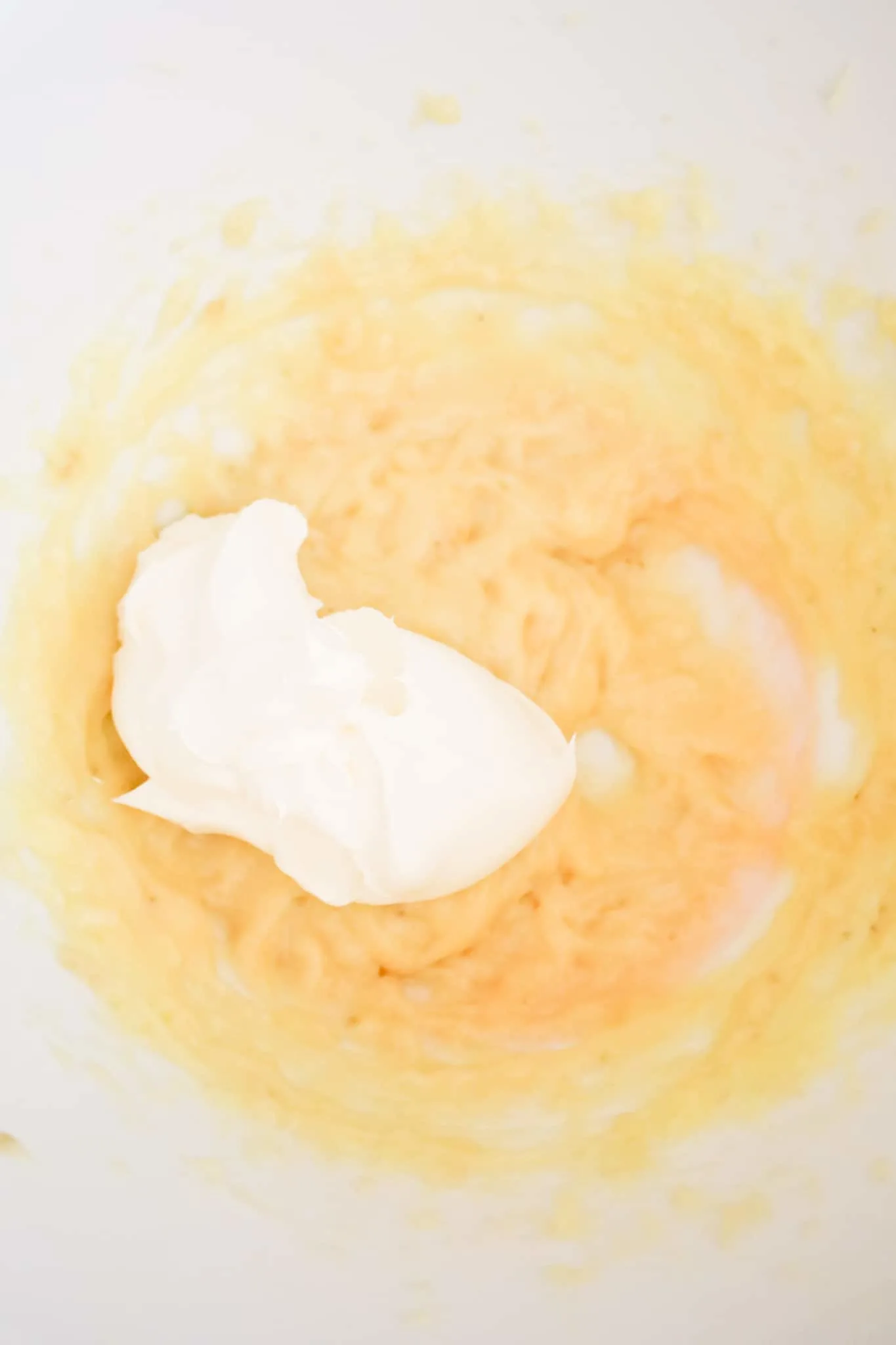 Cool Whip on top of banana pudding mixture in a mixing bowl