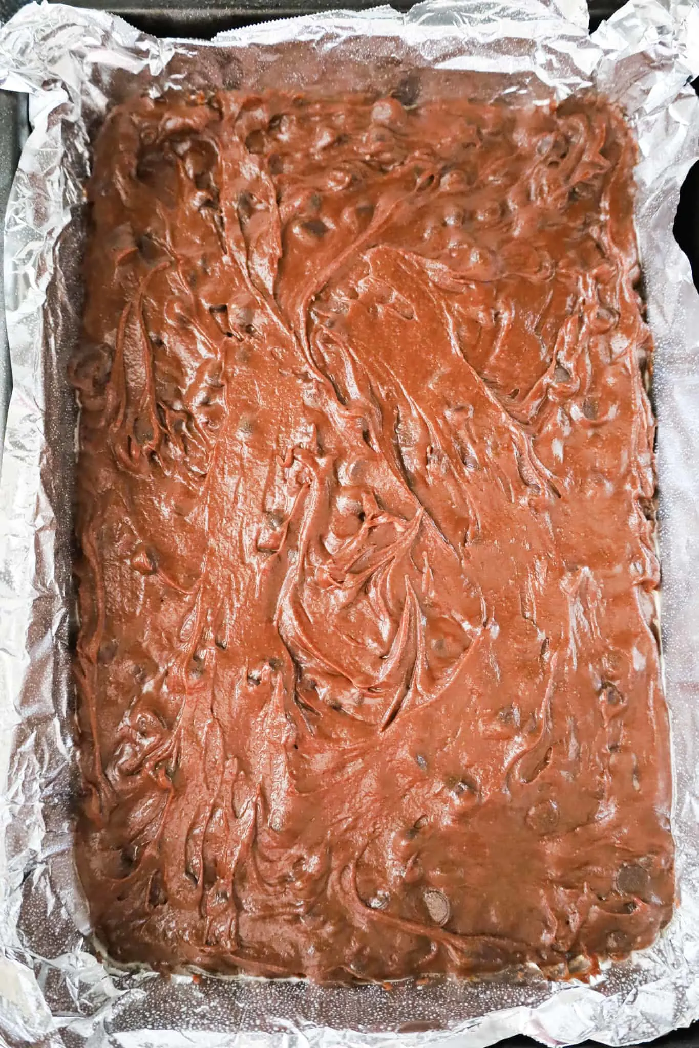 brownie batter in a foil lined baking pan