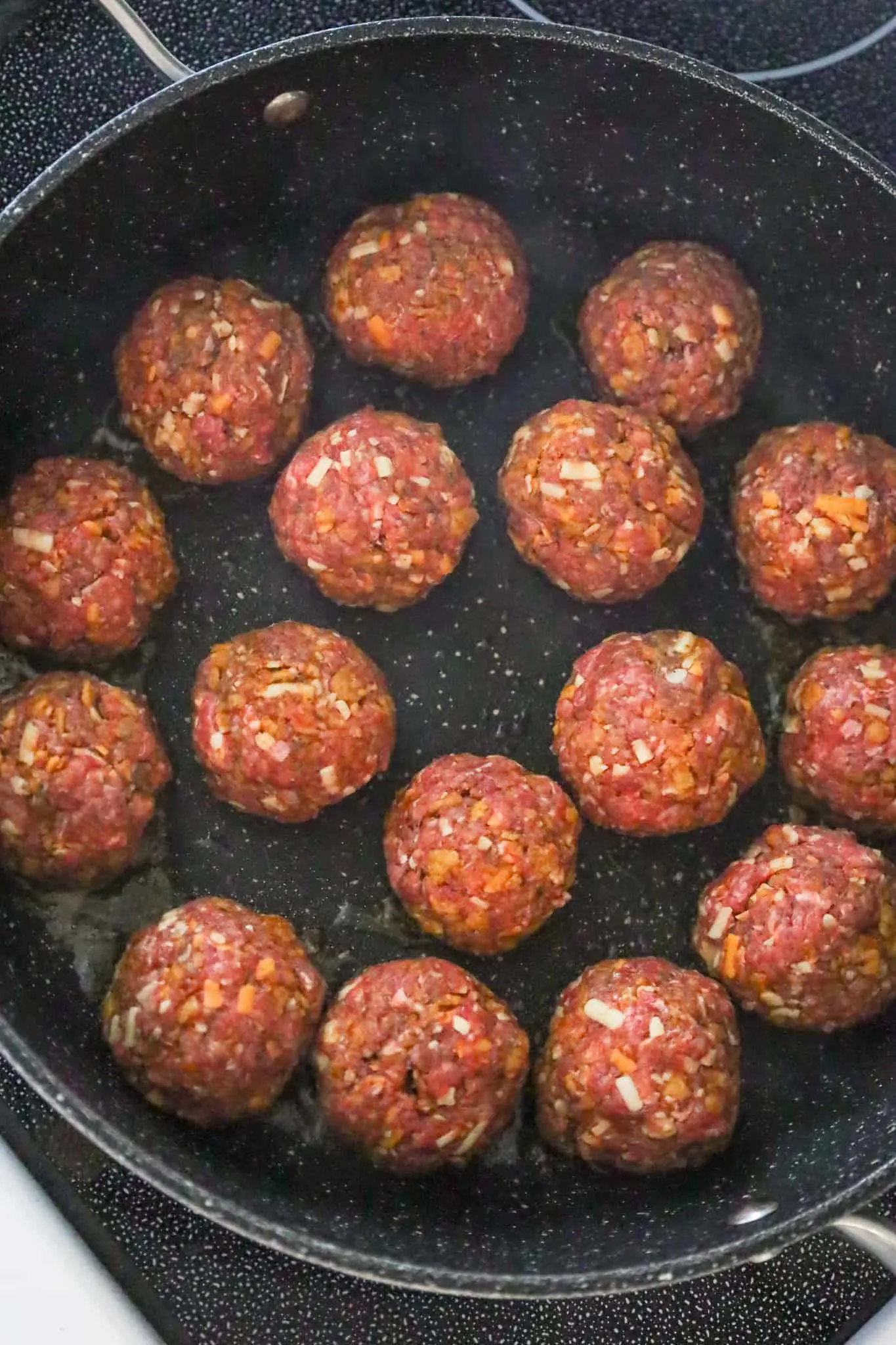 raw meatballs in a skillet