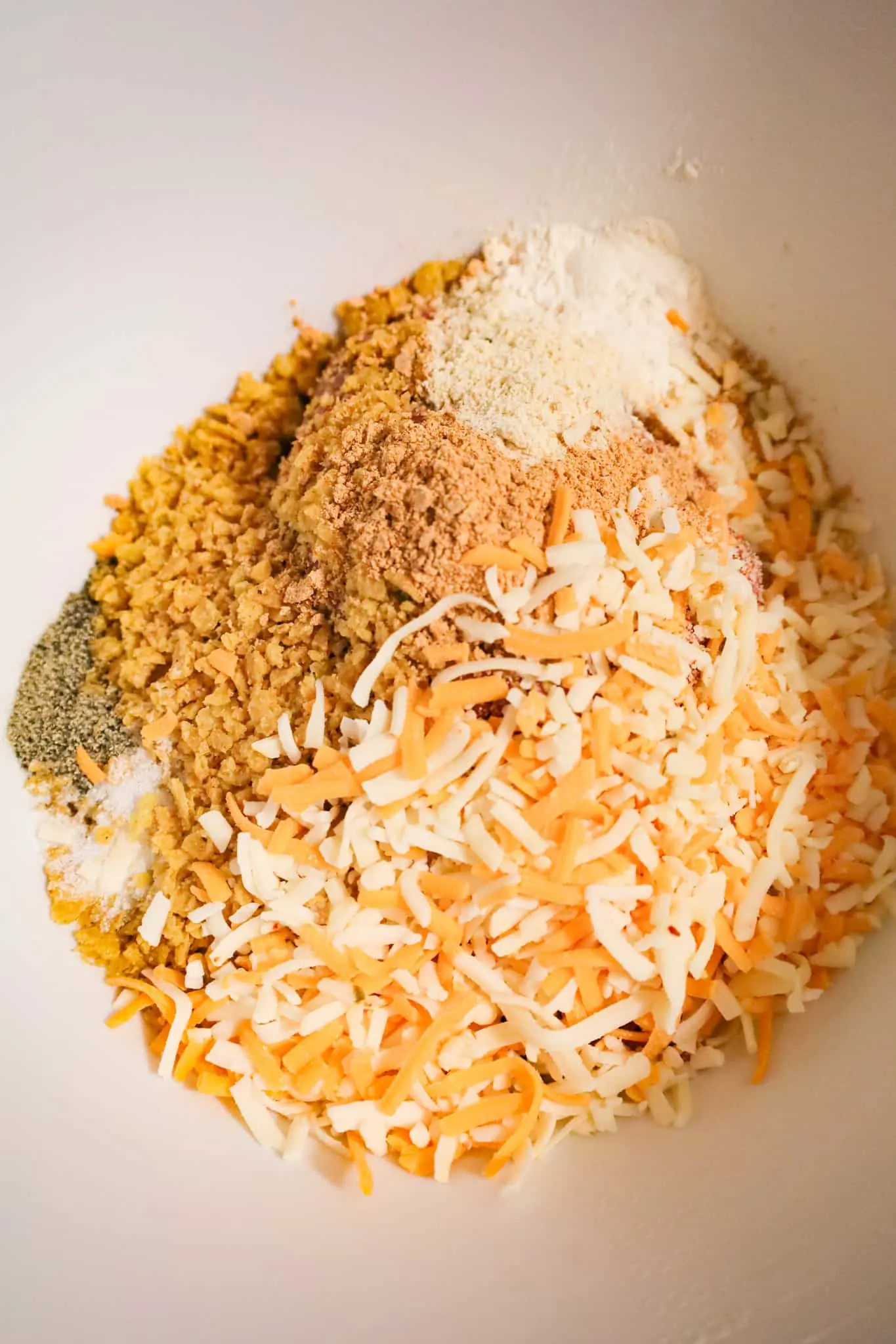 shredded cheese, crushed corn chips, spices and ground beef in a mixing bowl