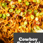 Cowboy Spaghetti is a robust pasta dish abundant with bacon, ground beef, Rotel diced tomatoes, green chilies, tomato sauce, BBQ sauce, shredded cheese, and finely chopped green onions.