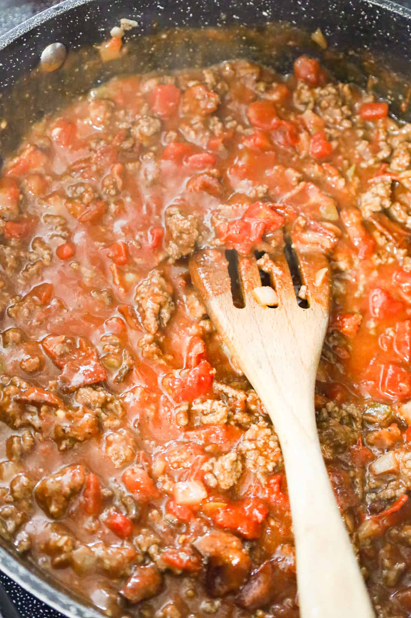 ground beef and sauce mixture in a skillet with diced tomatoes