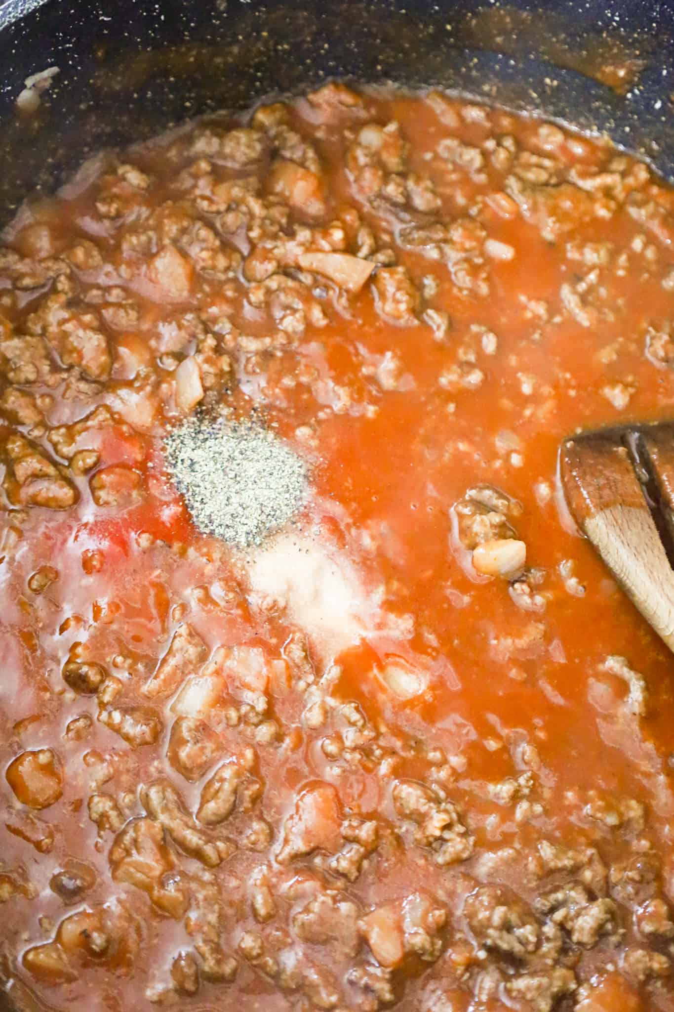 salt and pepper on top of sauce and ground beef mixture in a skillet