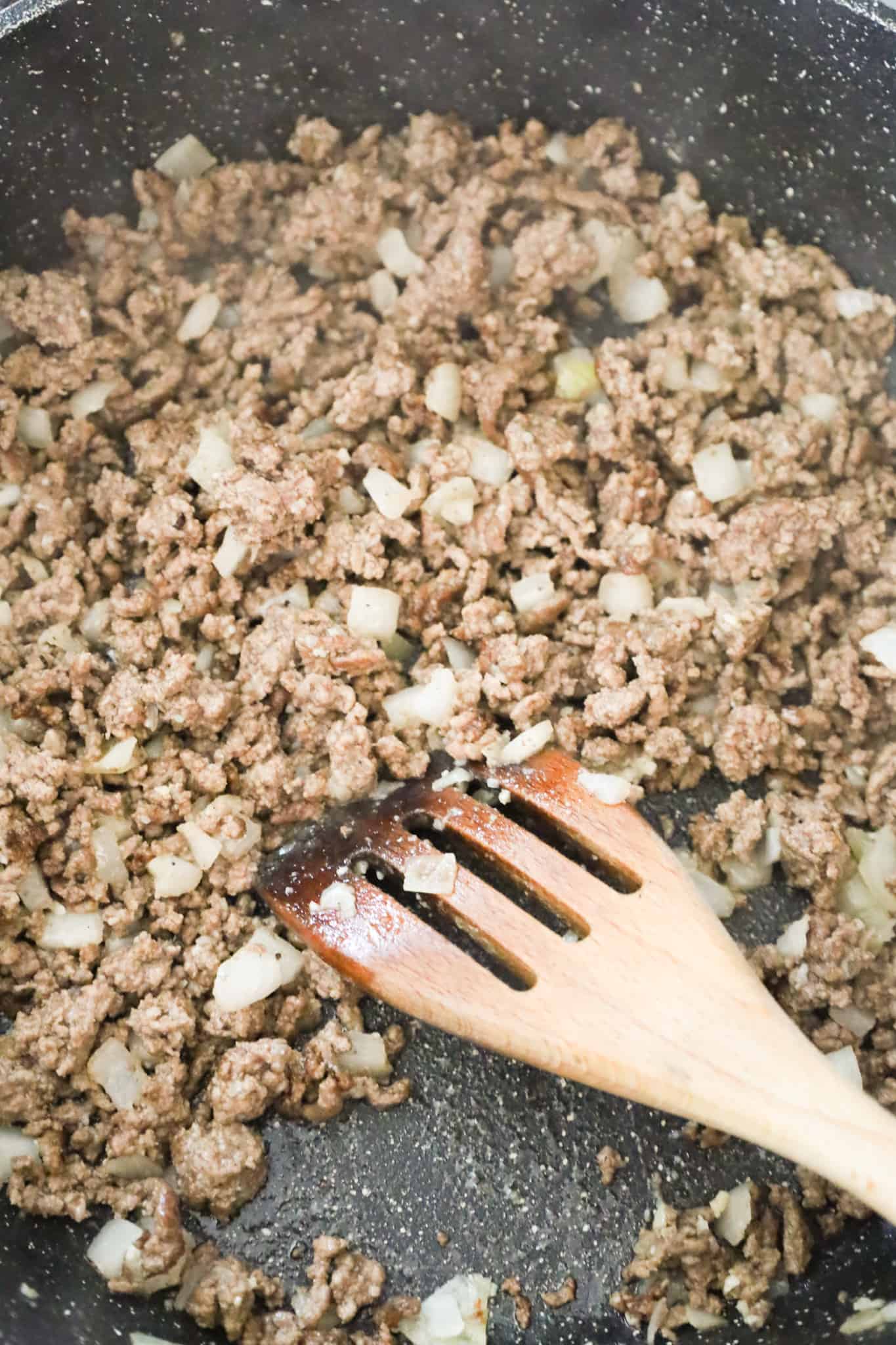 cooked ground beef and diced onions in a skillet