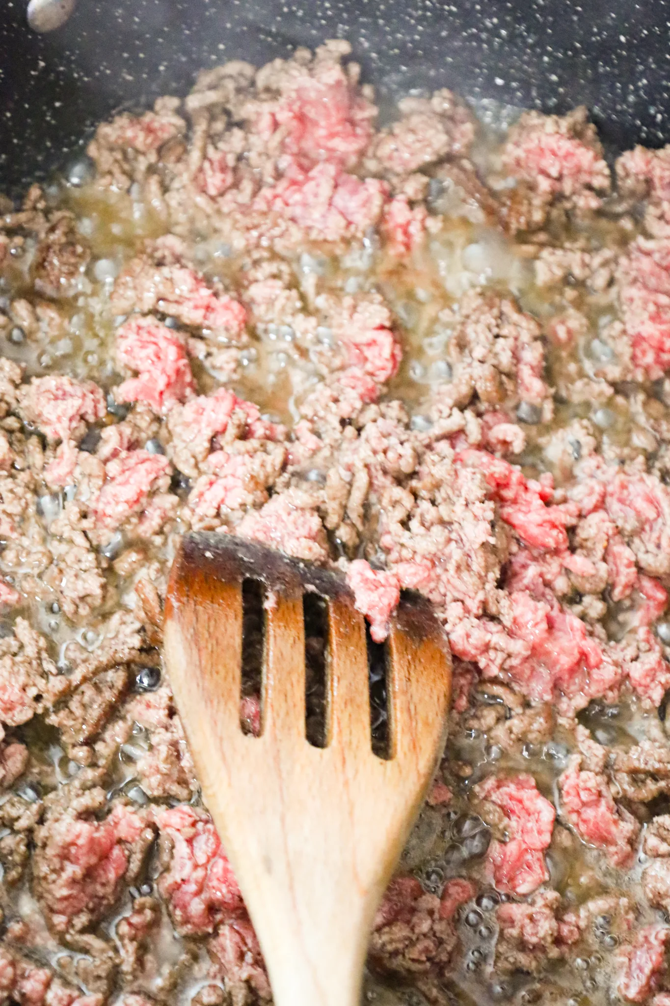 ground beef cooking in a skillet with bacon grease