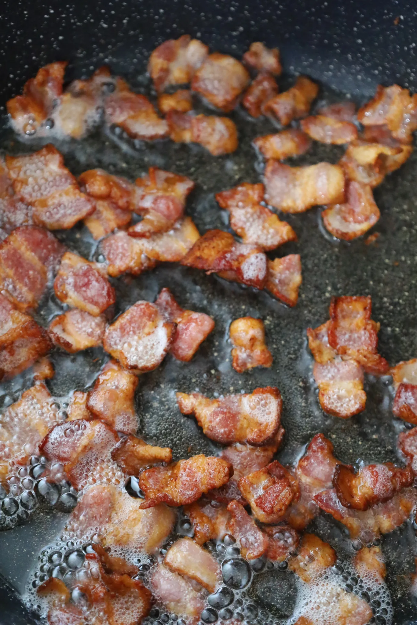 cooked bacon pieces in a skillet