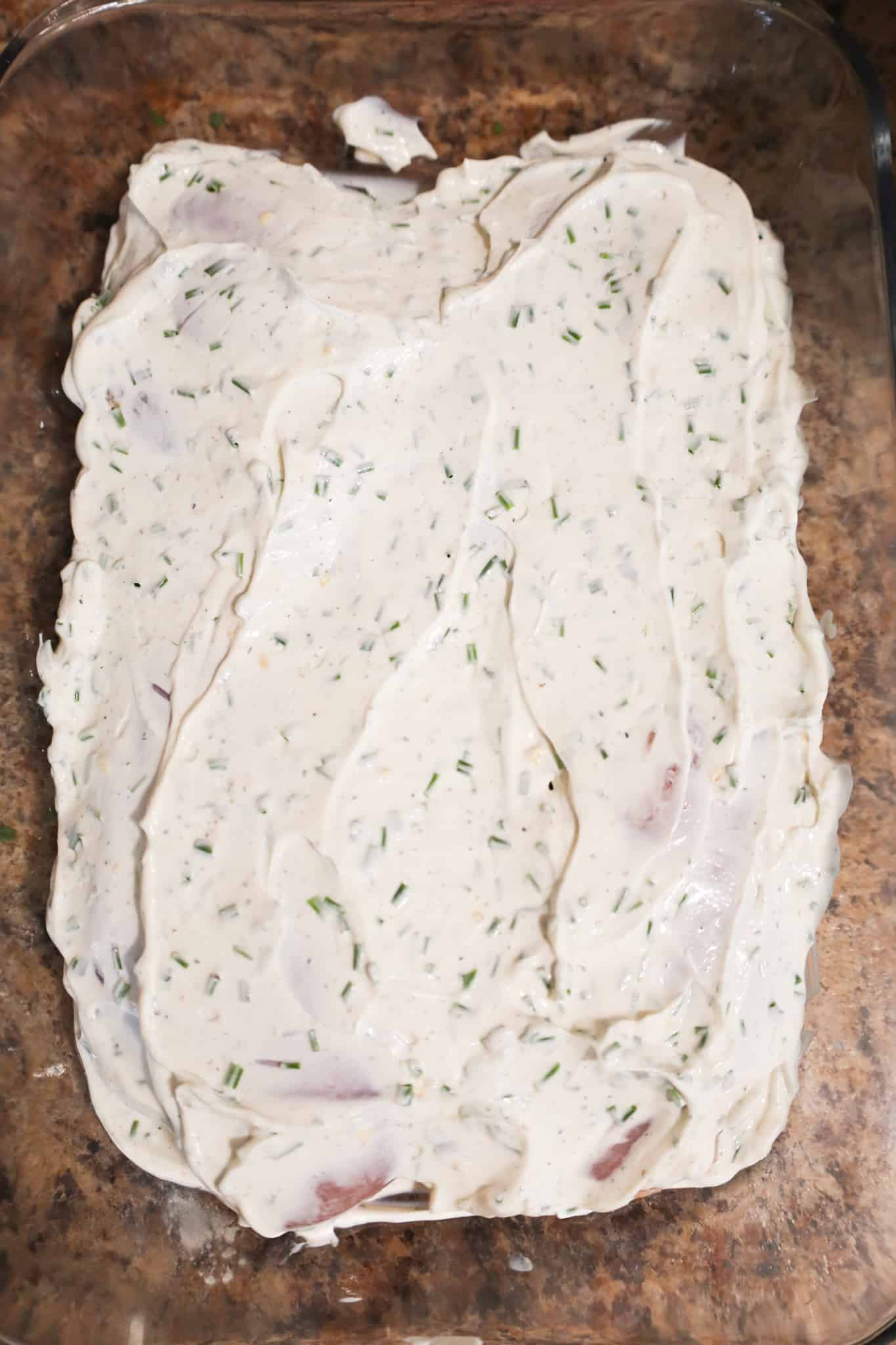 sour cream mixture on top of chicken breasts in a baking dish