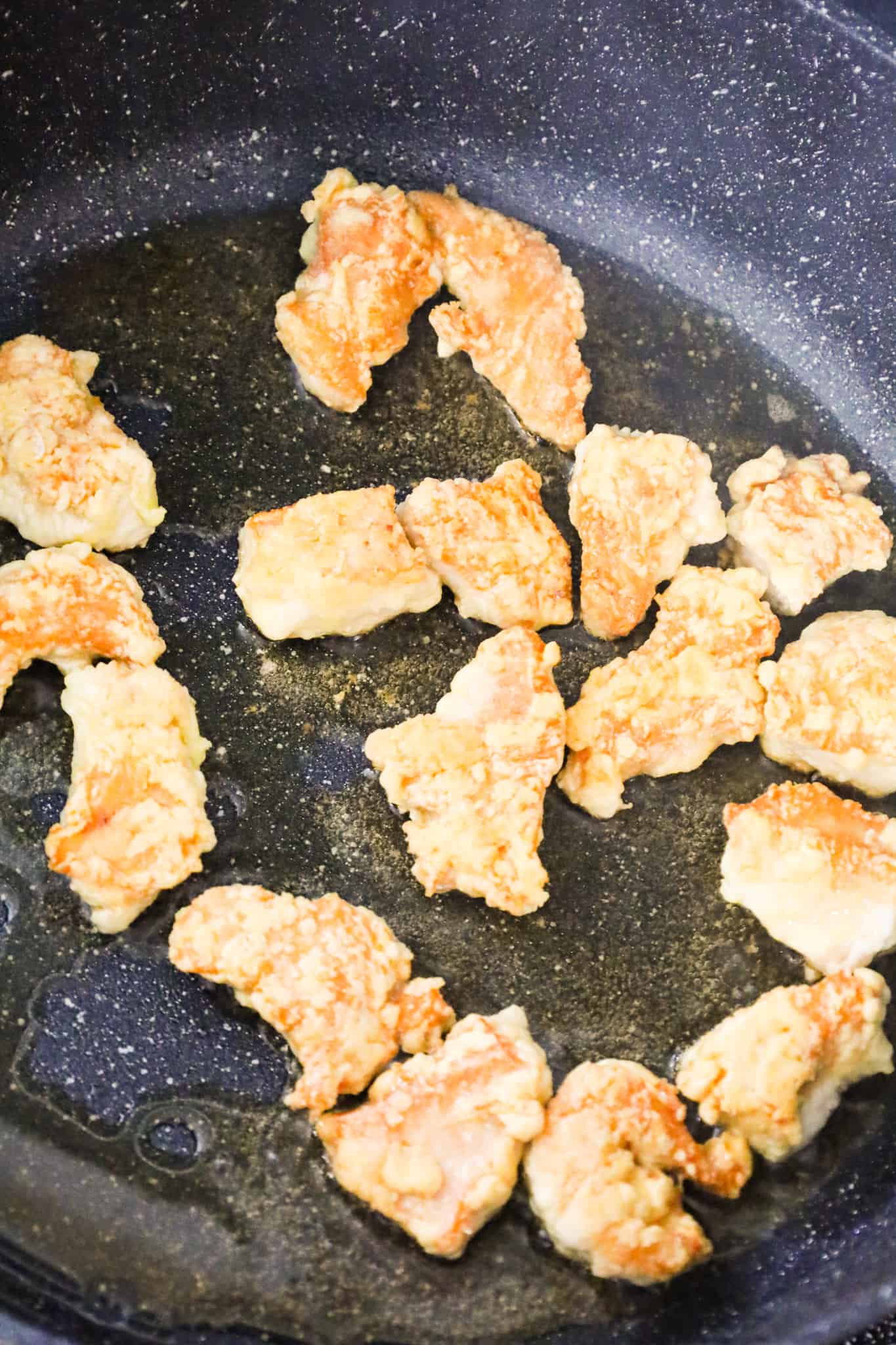 breaded chicken chunks cooking in a skillet