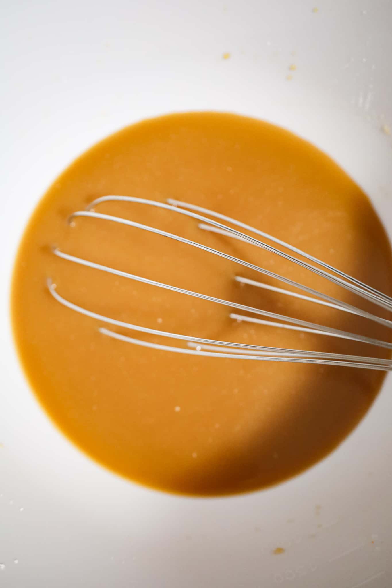 whisking empress chicken sauce in a mixing bowl