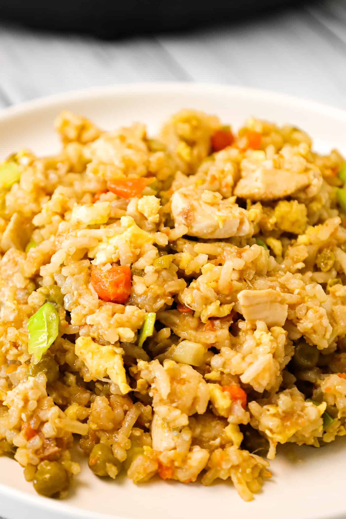 Instant Pot Chicken Fried Rice is an easy pressure cooker dinner recipe made with long grain white rice, boneless skinless chicken breasts, scrambled eggs and peas and carrots all seasoned with chicken broth, soy sauce and toasted sesame oil.