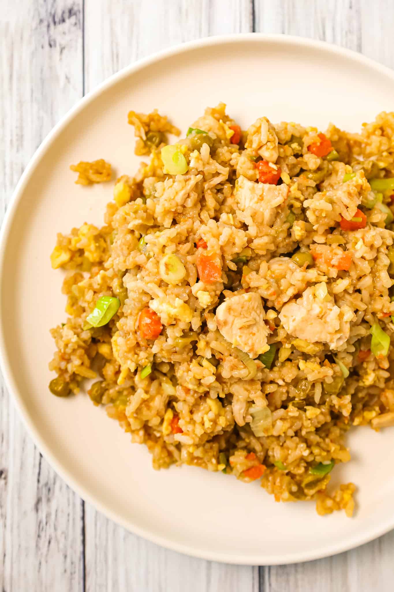 Instant Pot Chicken Fried Rice is an easy pressure cooker dinner recipe made with long grain white rice, boneless skinless chicken breasts, scrambled eggs and peas and carrots all seasoned with chicken broth, soy sauce and toasted sesame oil.