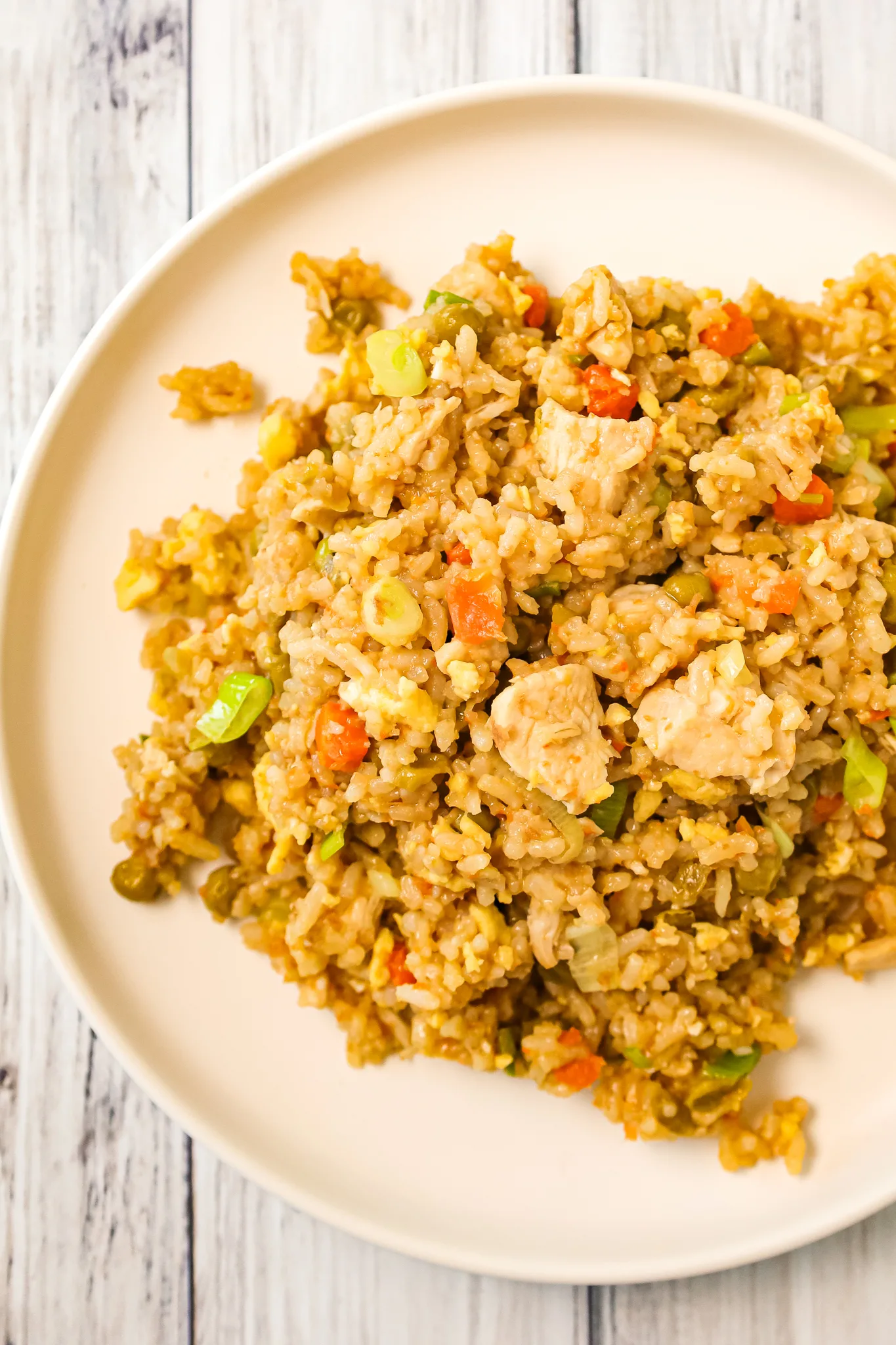 Instant Pot Chicken Fried Rice is an easy pressure cooker dinner recipe made with long grain white rice, boneless skinless chicken breasts, scrambled eggs and peas and carrots all seasoned with chicken broth, soy sauce and toasted sesame oil.