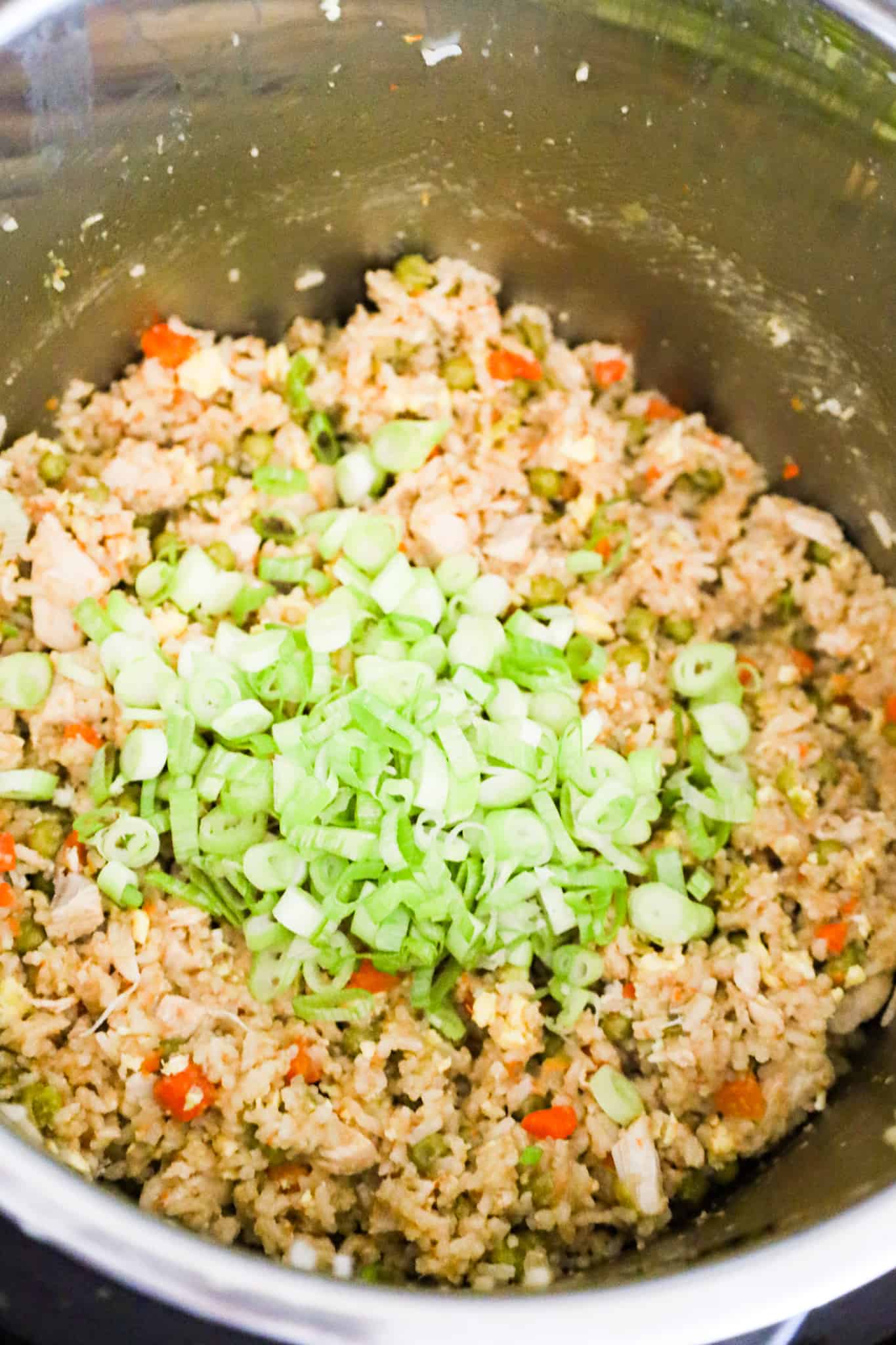 chopped green onions on top of chicken fried rice in an Instant Pot