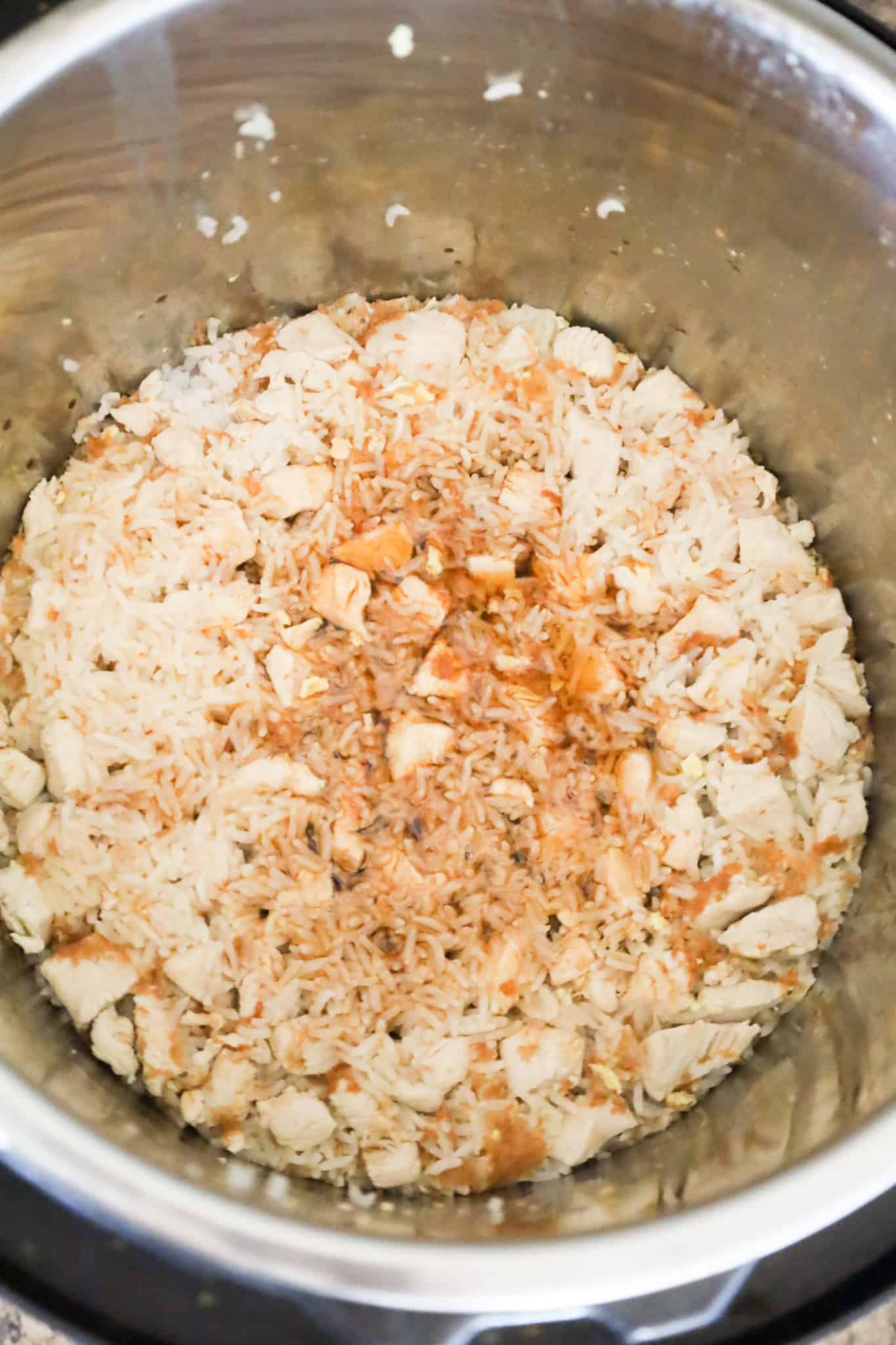 soy sauce and toasted sesame oil added to cooked chicken and rice in an Instant Pot