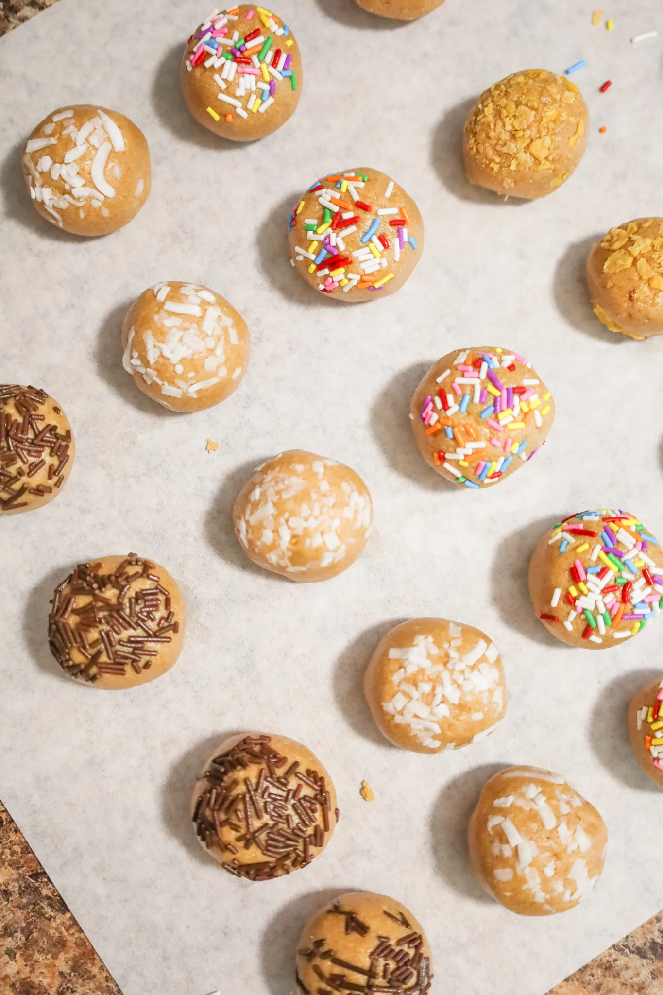 peanut butter balls with sprinkles on parchment paper
